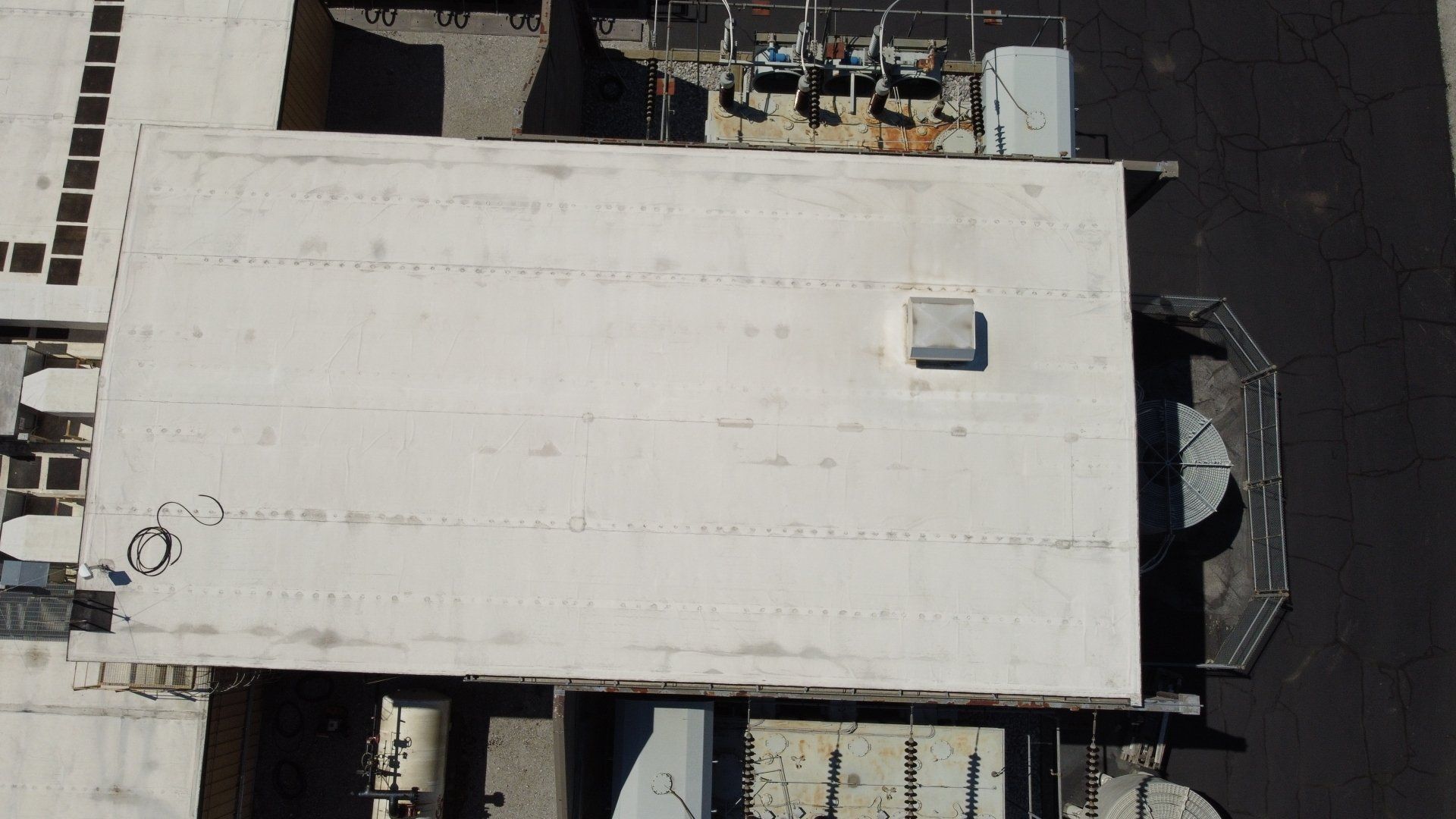 An aerial view of a building with a white roof