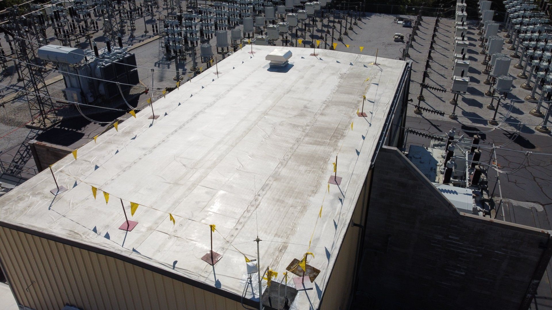 An aerial view of a large building with a white roof.