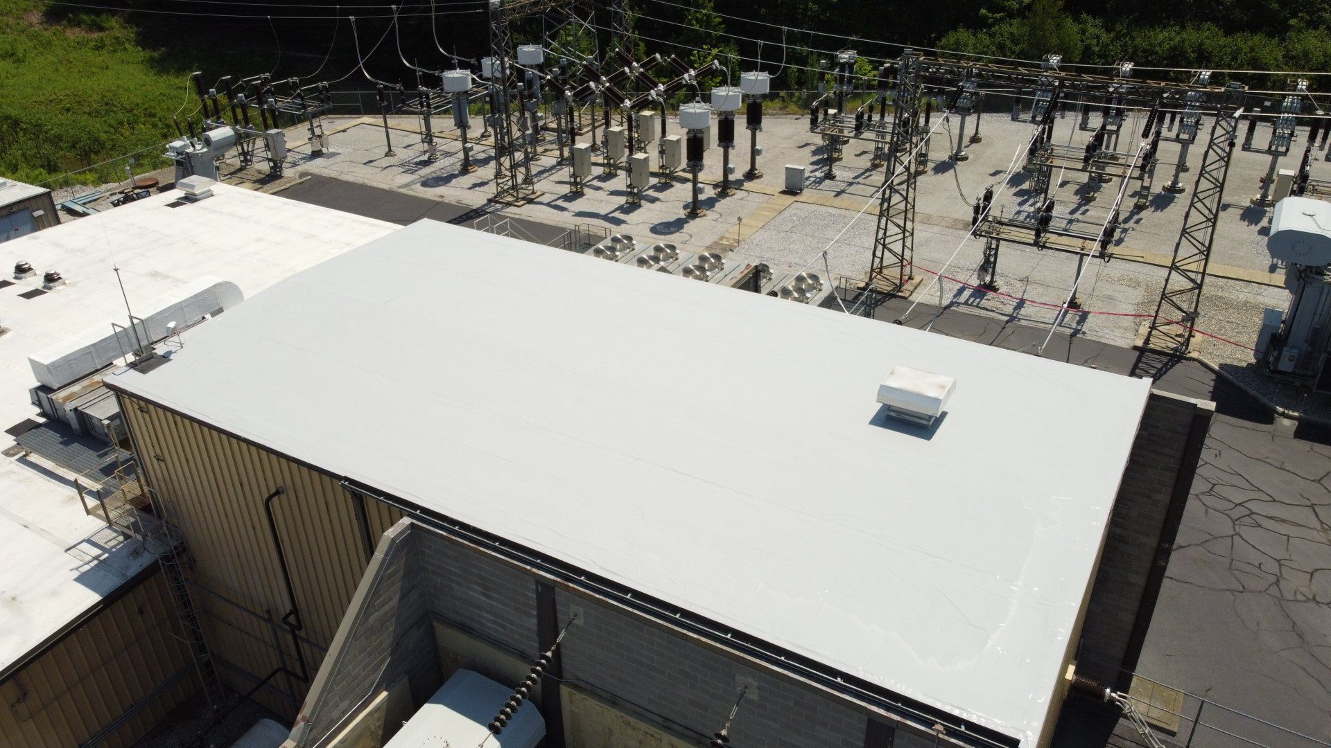 An aerial view of a large building with a white roof.
