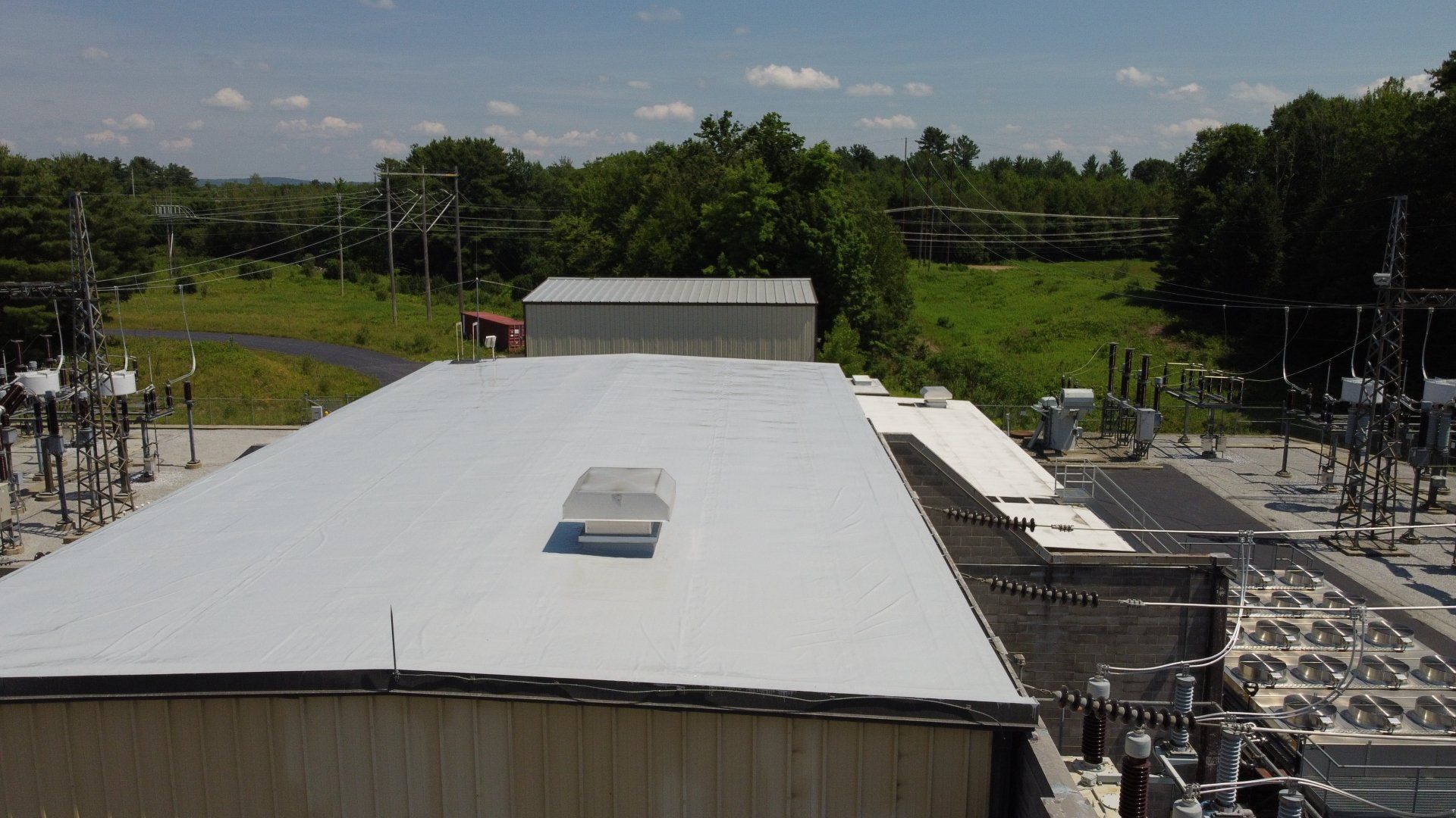 An aerial view of a large building with a white roof.