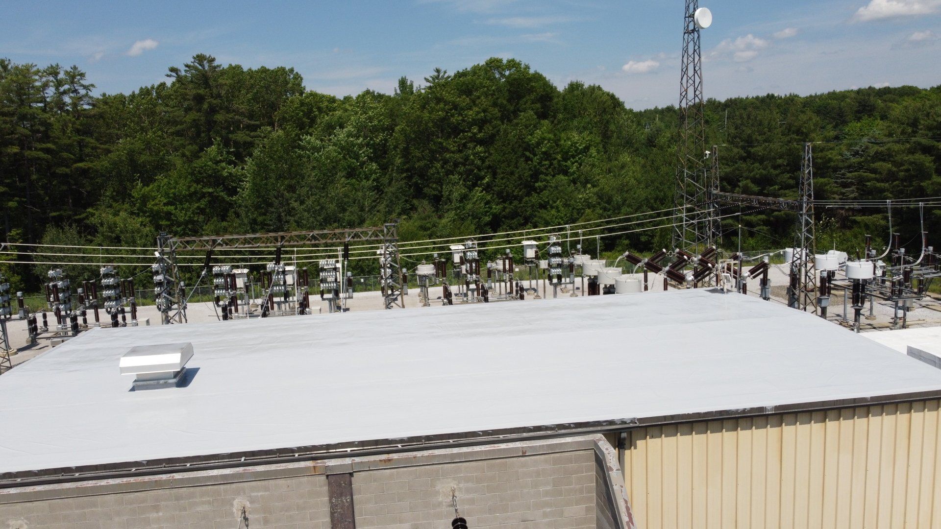 An aerial view of a roof of a building with trees in the background.