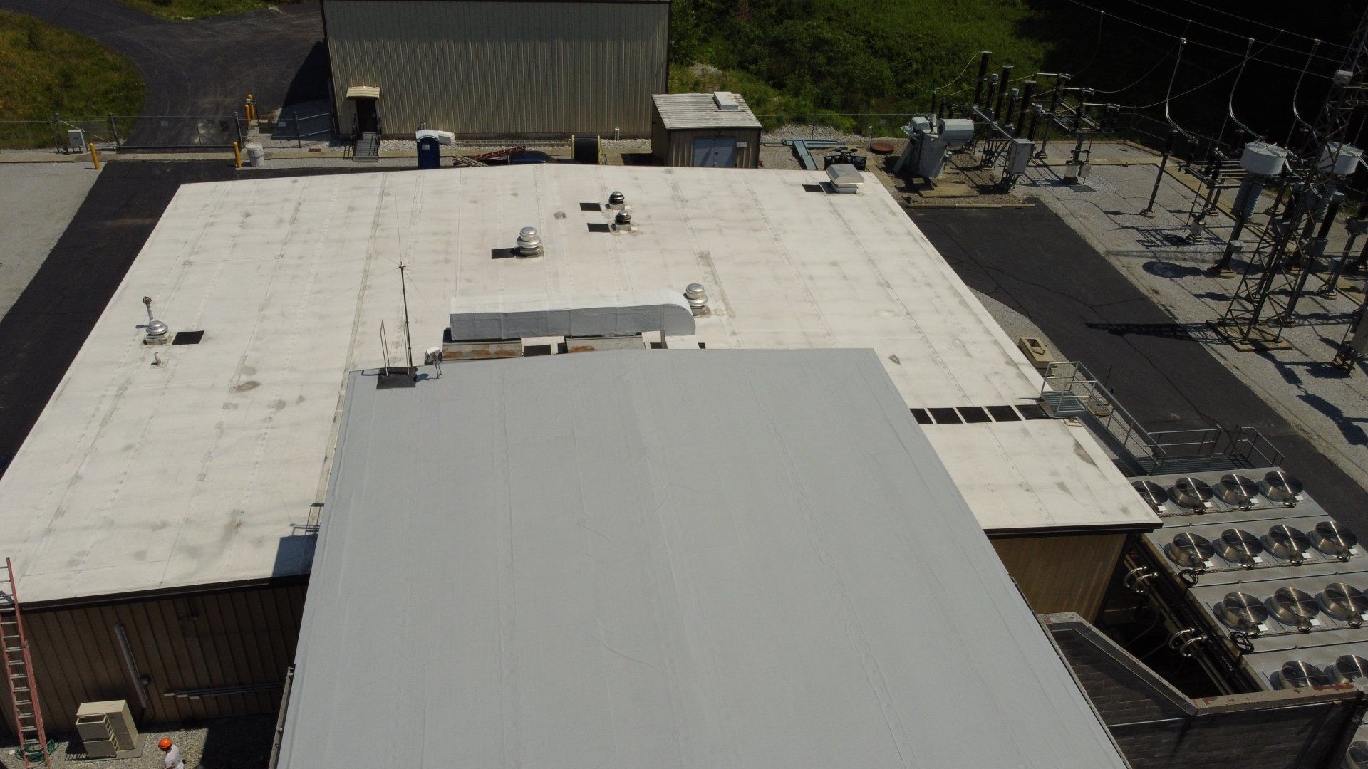 An aerial view of a large building with a white roof