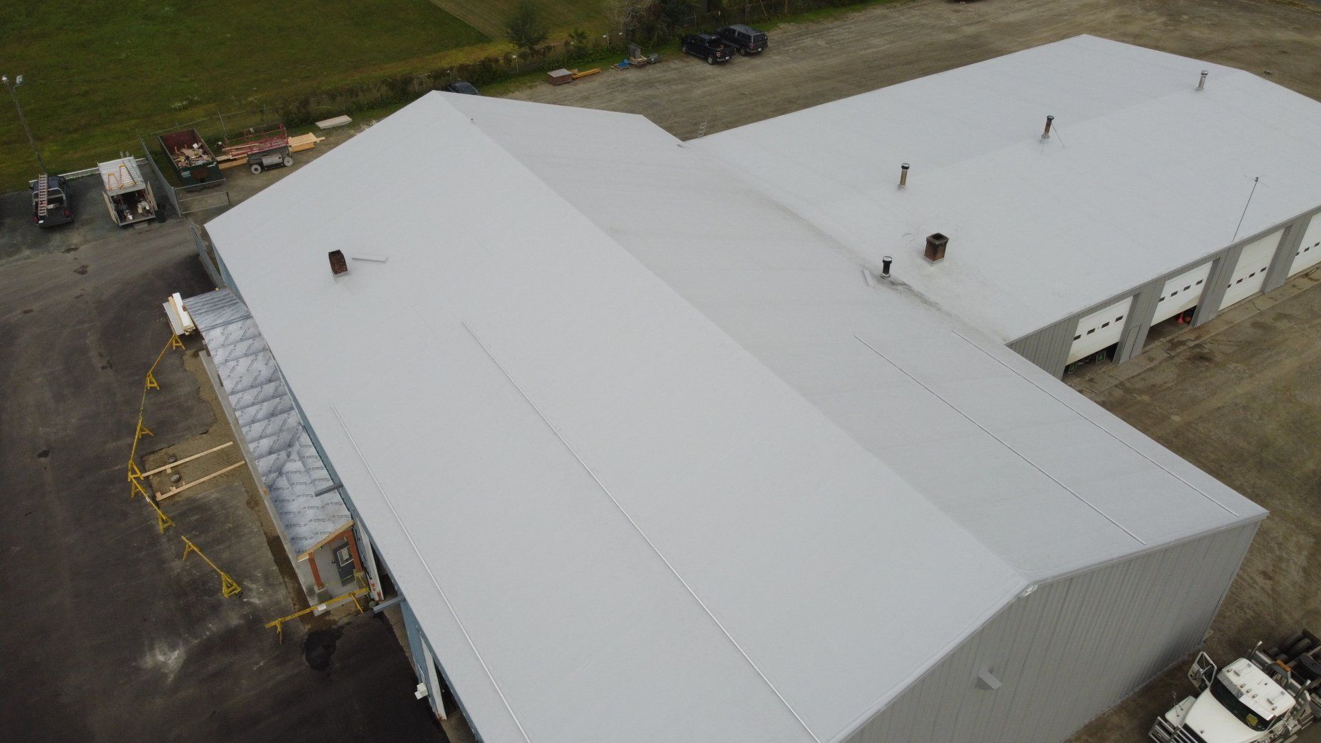 Aerial view of a large industrial building with a new metal retrofit roof by Rodd Roofing.