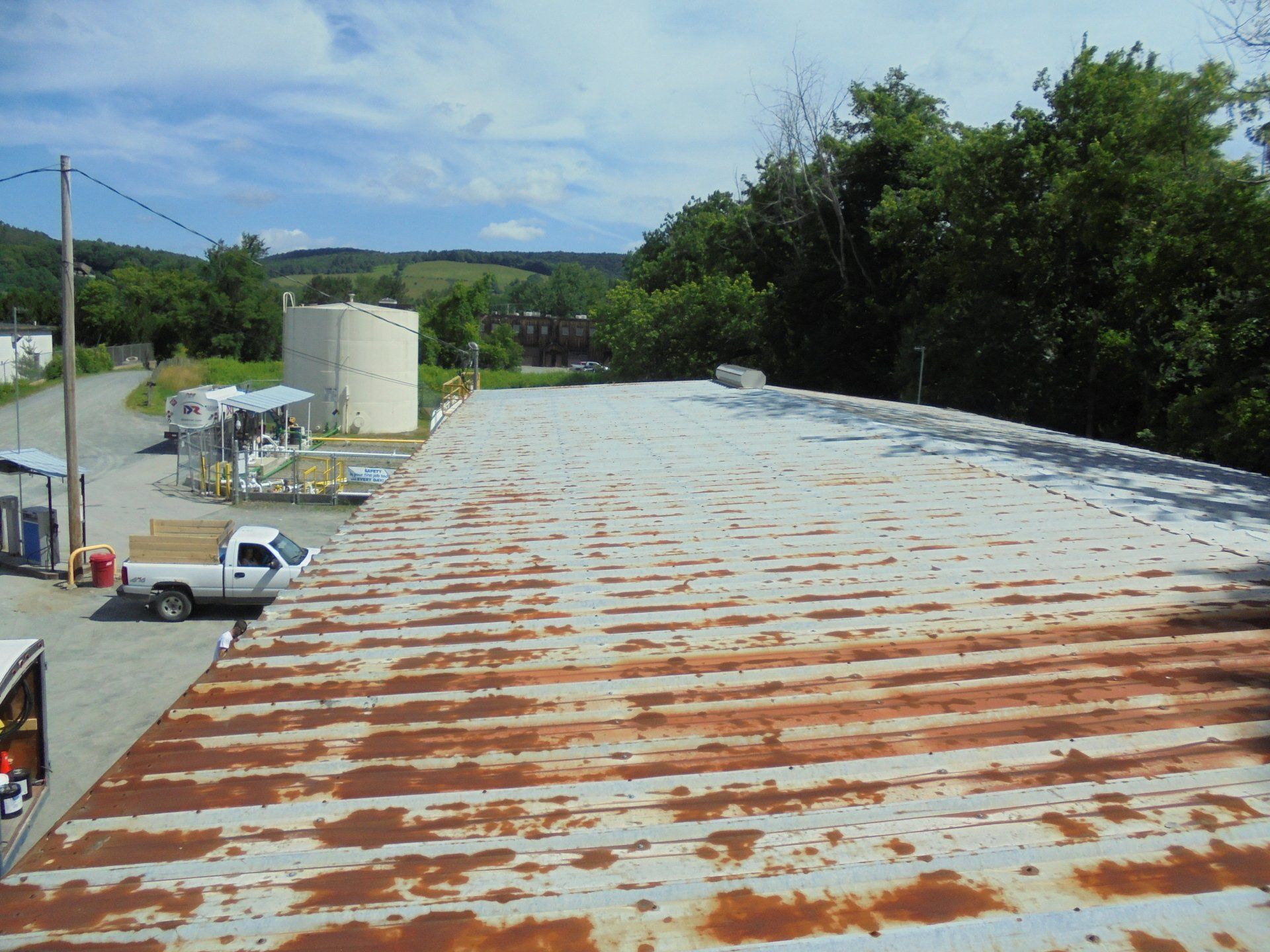 A rusty roof with a white truck parked on it