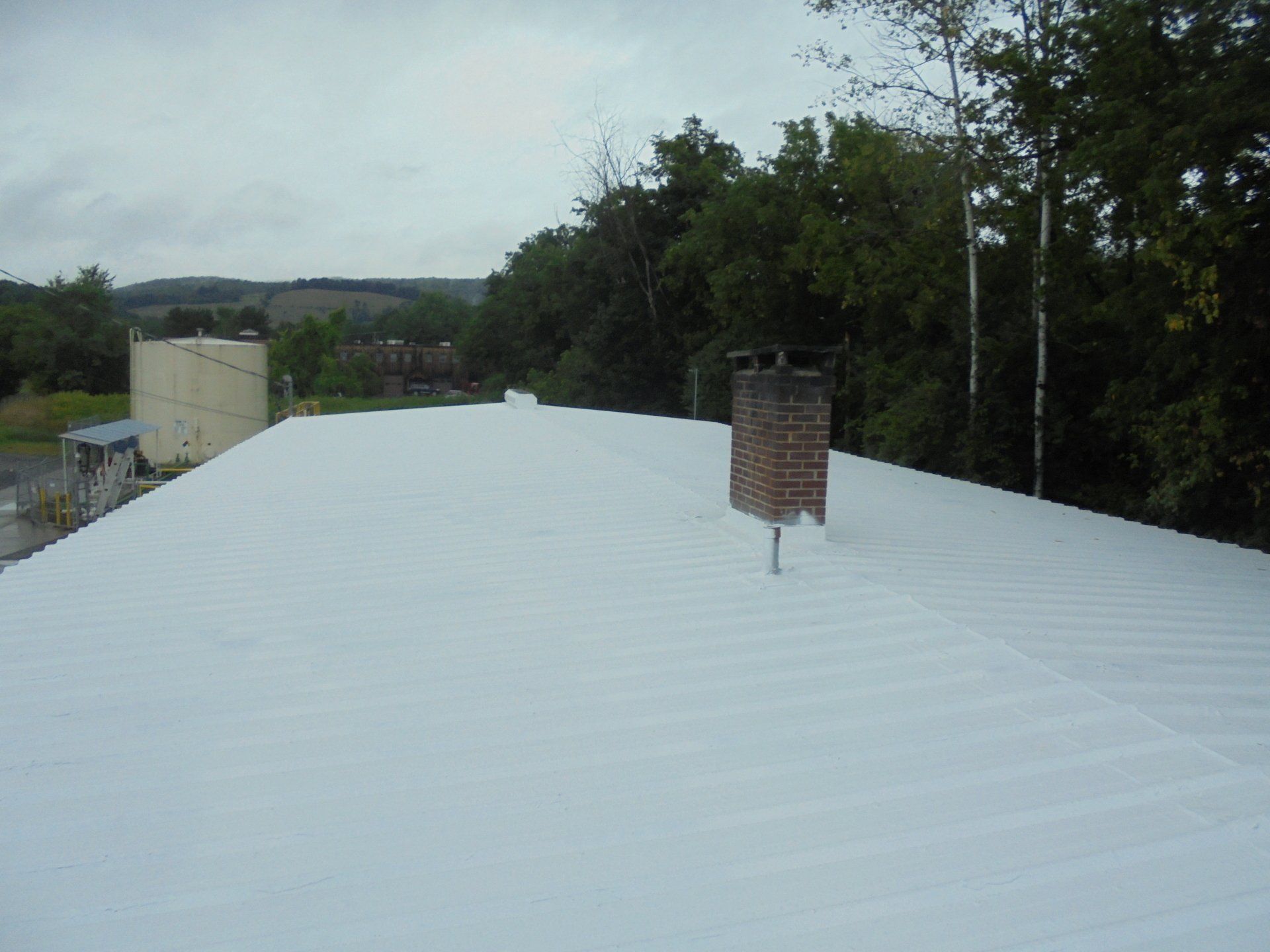 A white roof with a chimney on top of it