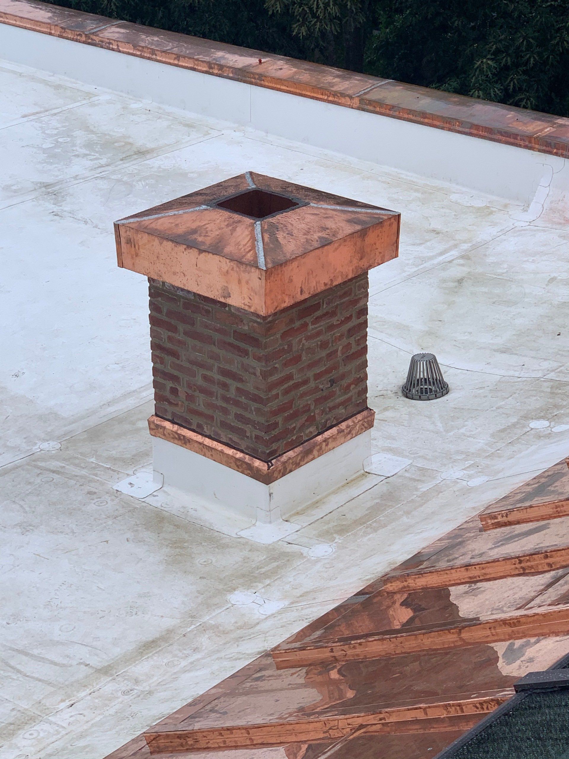brick chimney with copper at bottom and top