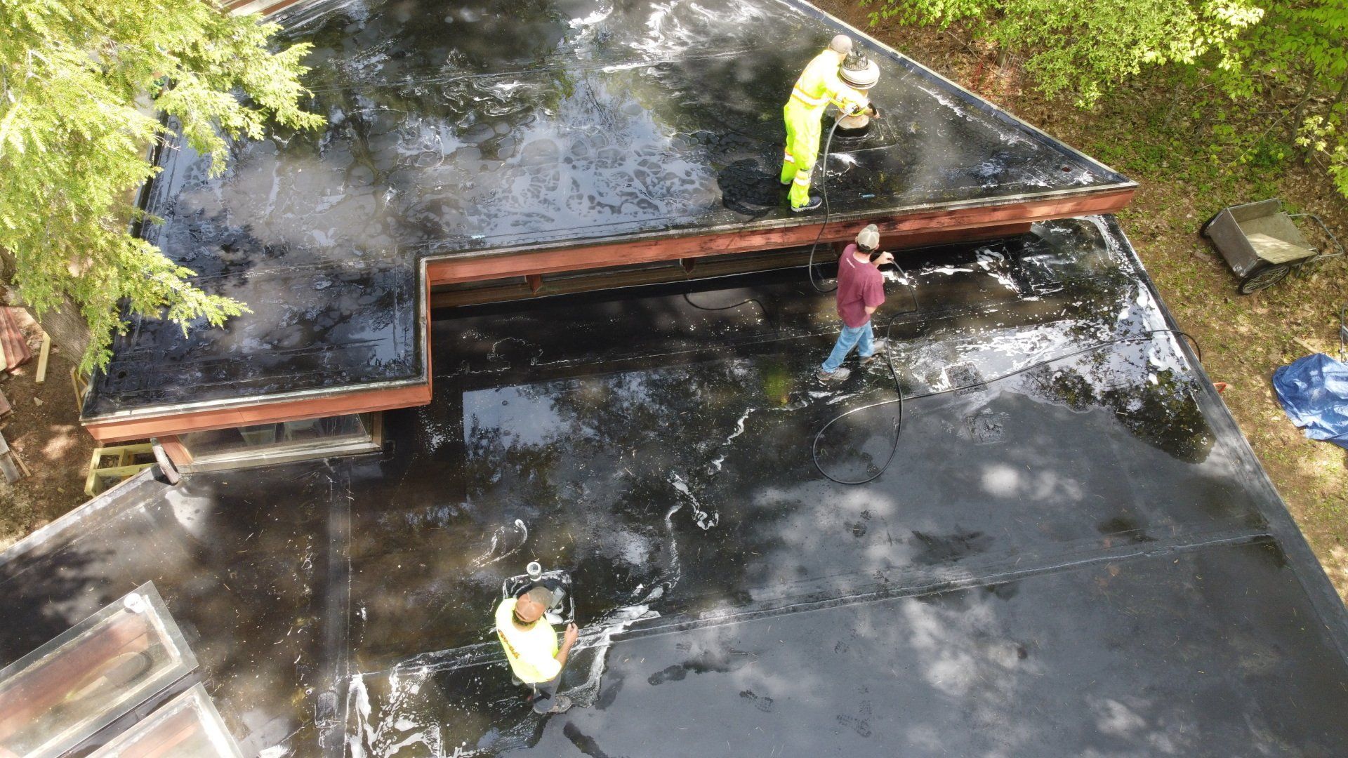 A group of people are working on a black roof.