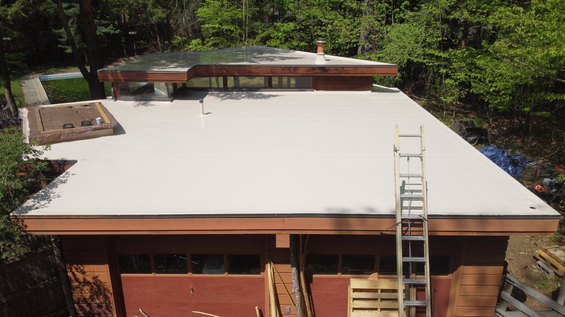 An aerial view of a house with a ladder on the roof.
