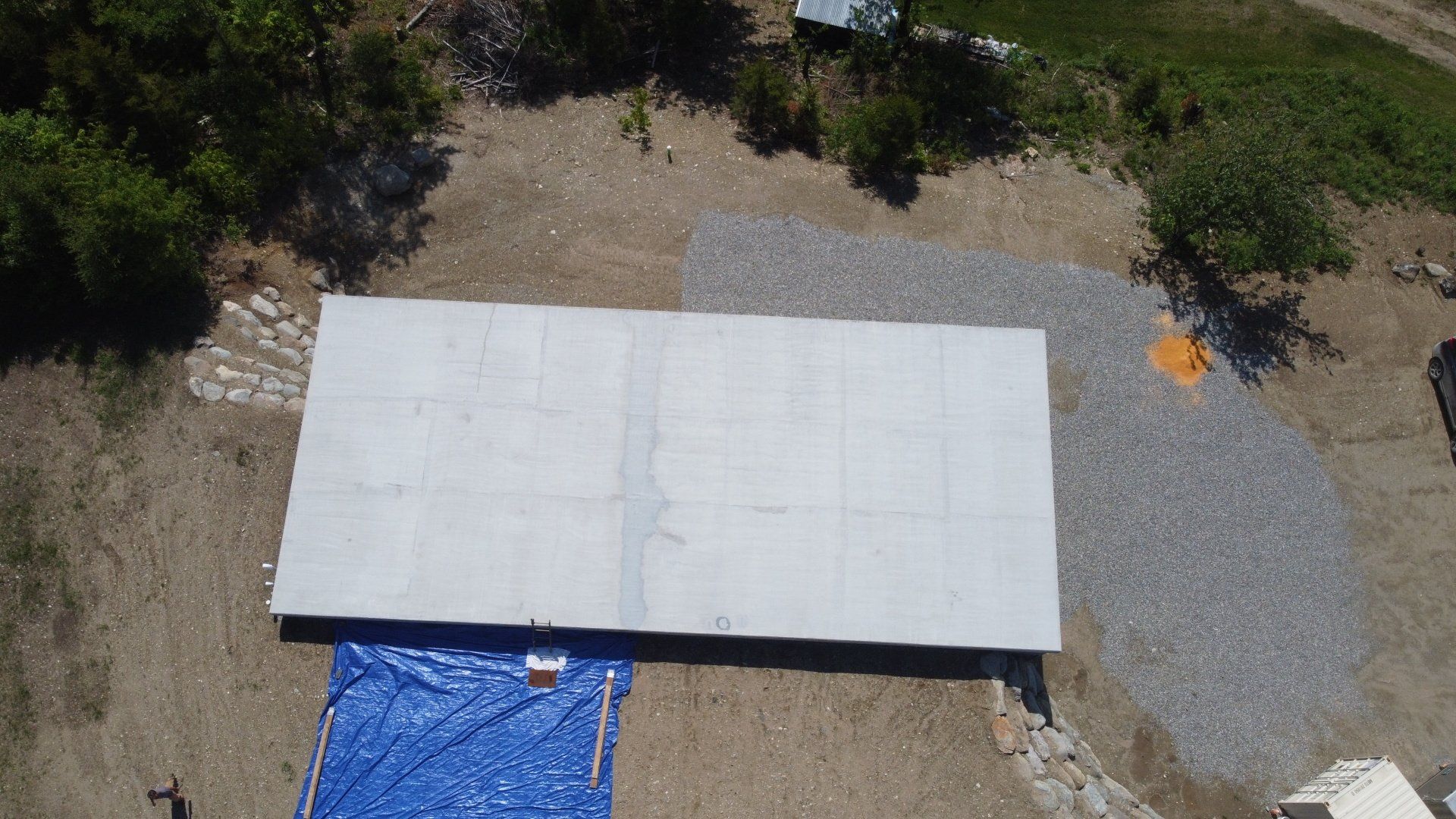 An aerial view of a large white tarp sitting on top of a dirt field.