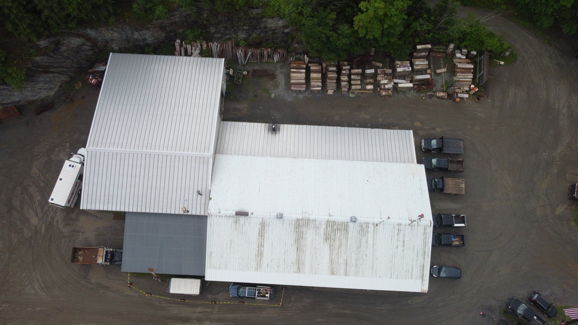 An aerial view of a large building with trucks parked in front of it.