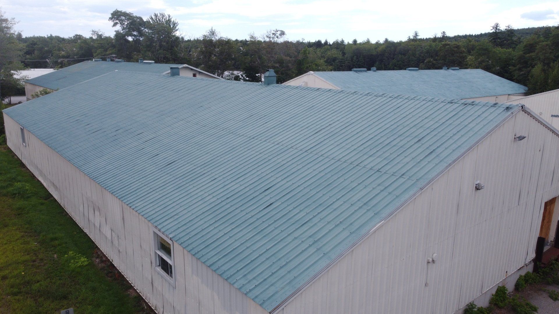 An aerial view of a white building with a blue roof.