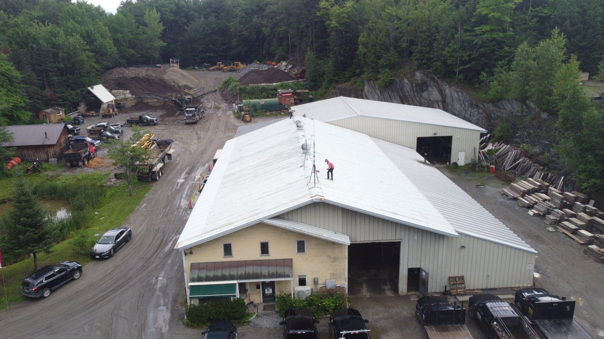 An aerial view of a large commercial building with a metal retrofit roof.