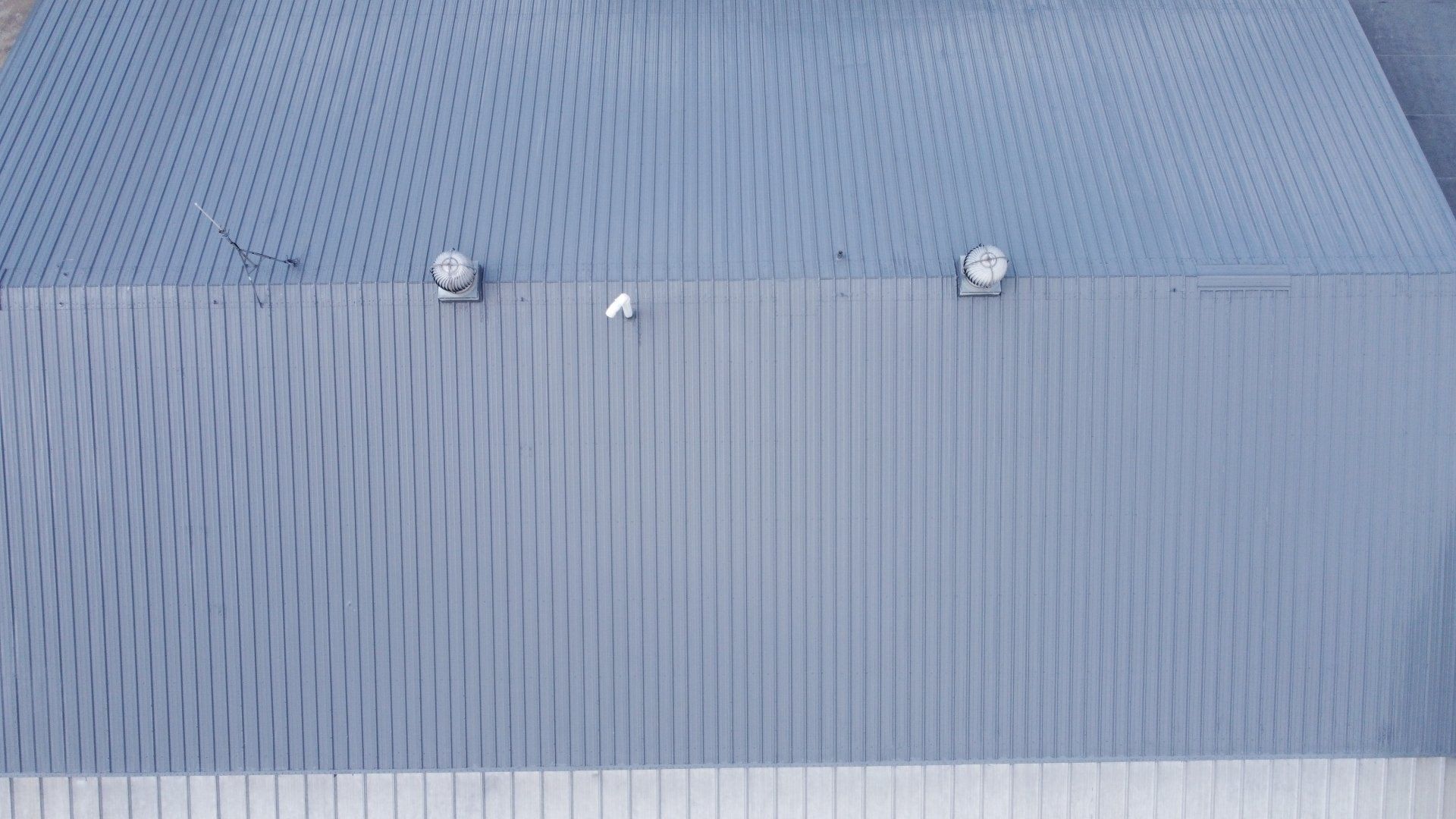An aerial view of a building with a gray roof.