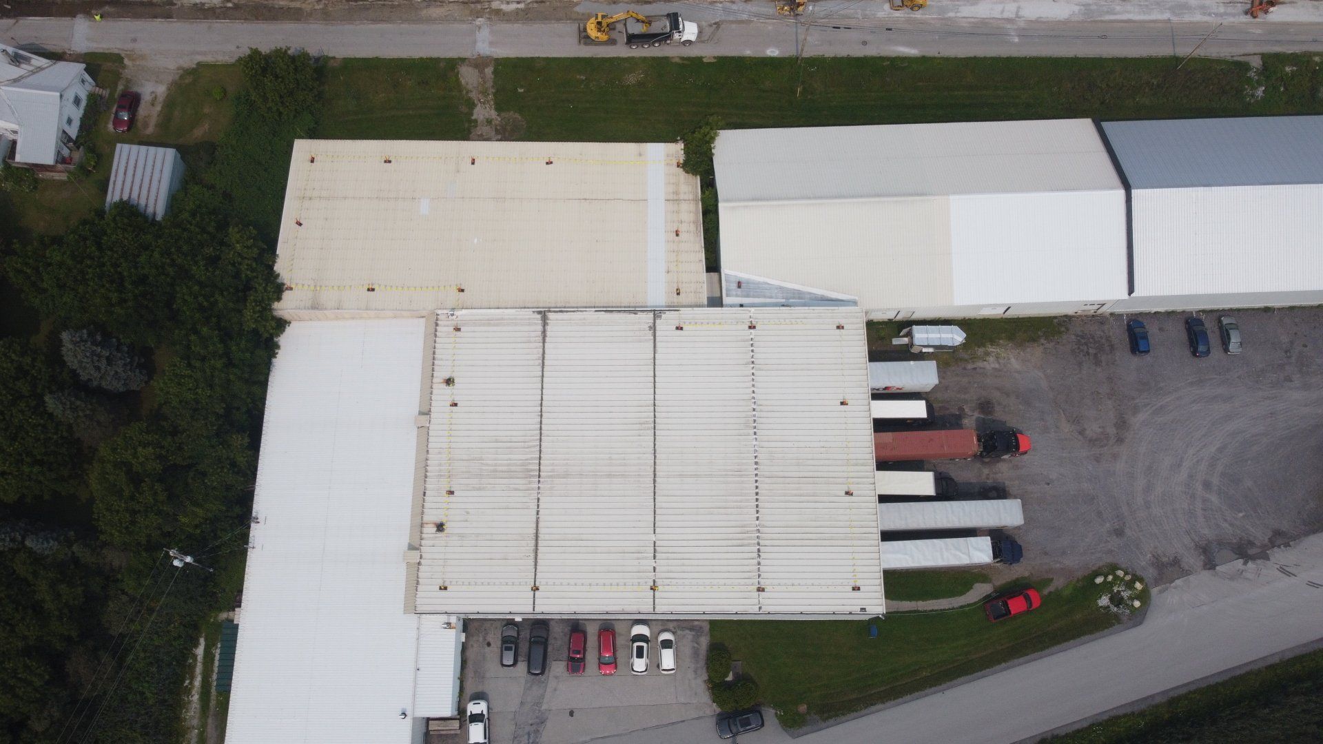 An aerial view of a large warehouse with trucks parked in front of it.