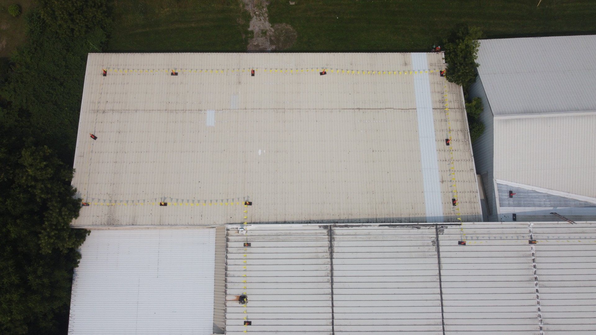 An aerial view of a roof of a building with trees in the background.