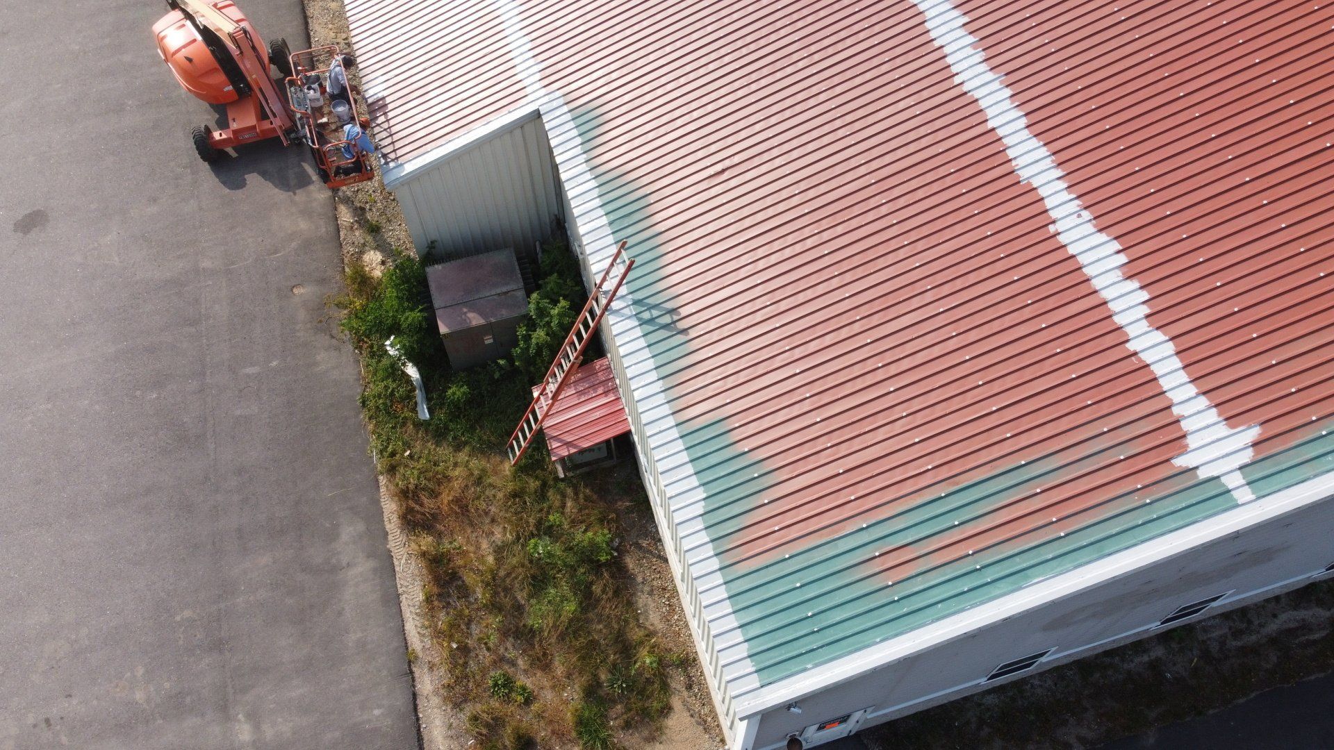 An aerial view of a building being painted red and green.