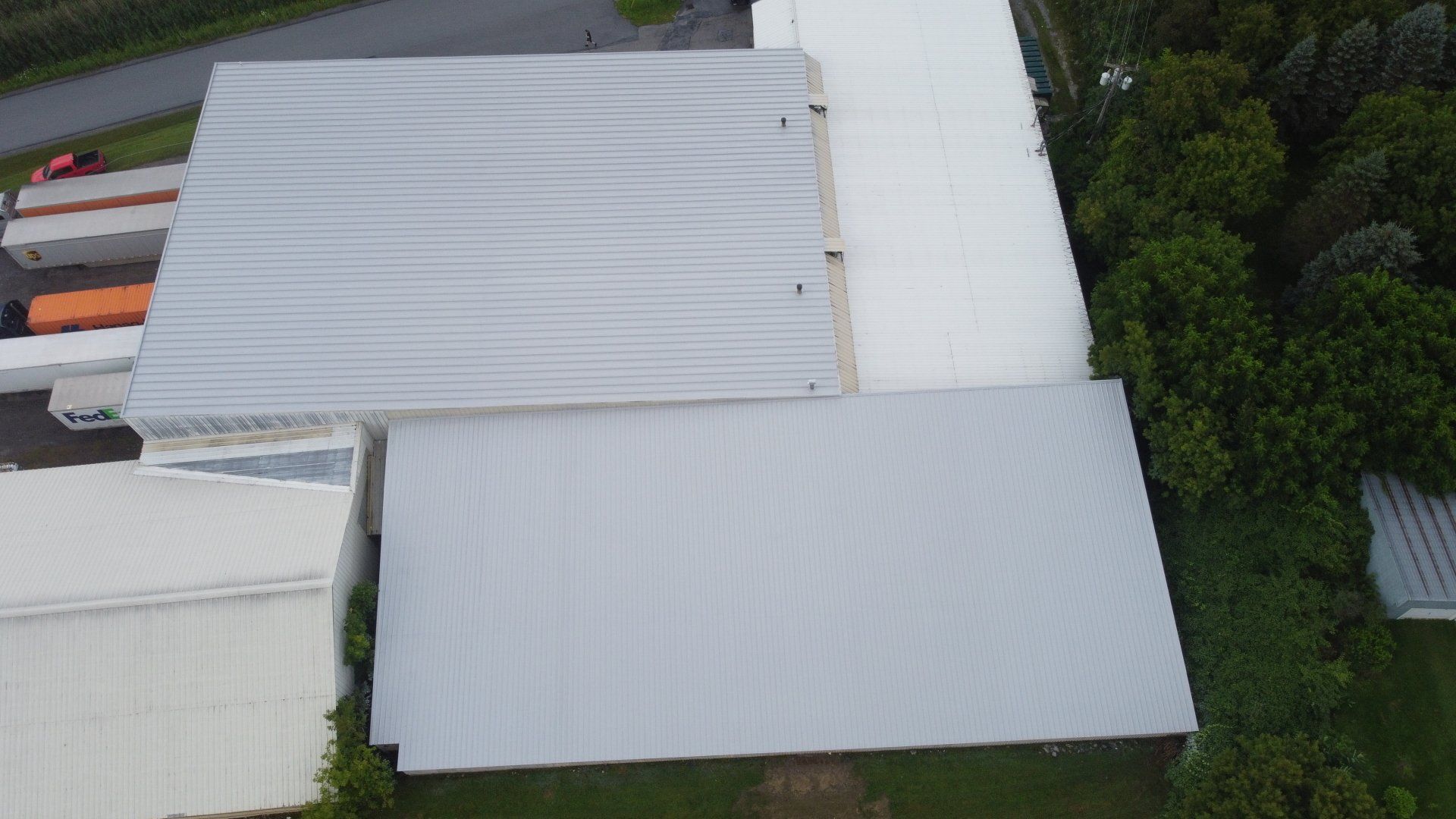 An aerial view of a large warehouse with a white roof.