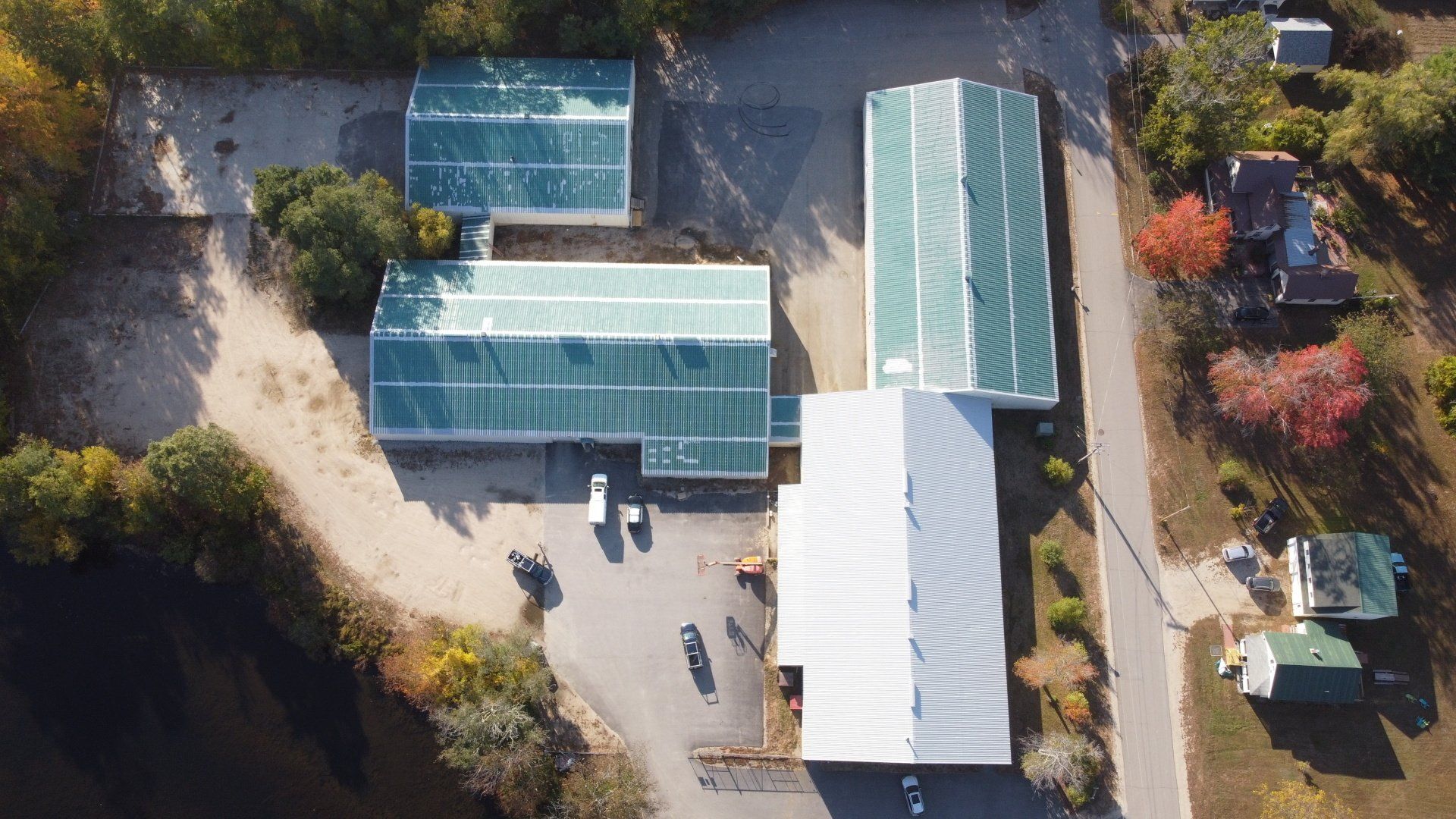 An aerial view of a large building with green roofs surrounded by trees.