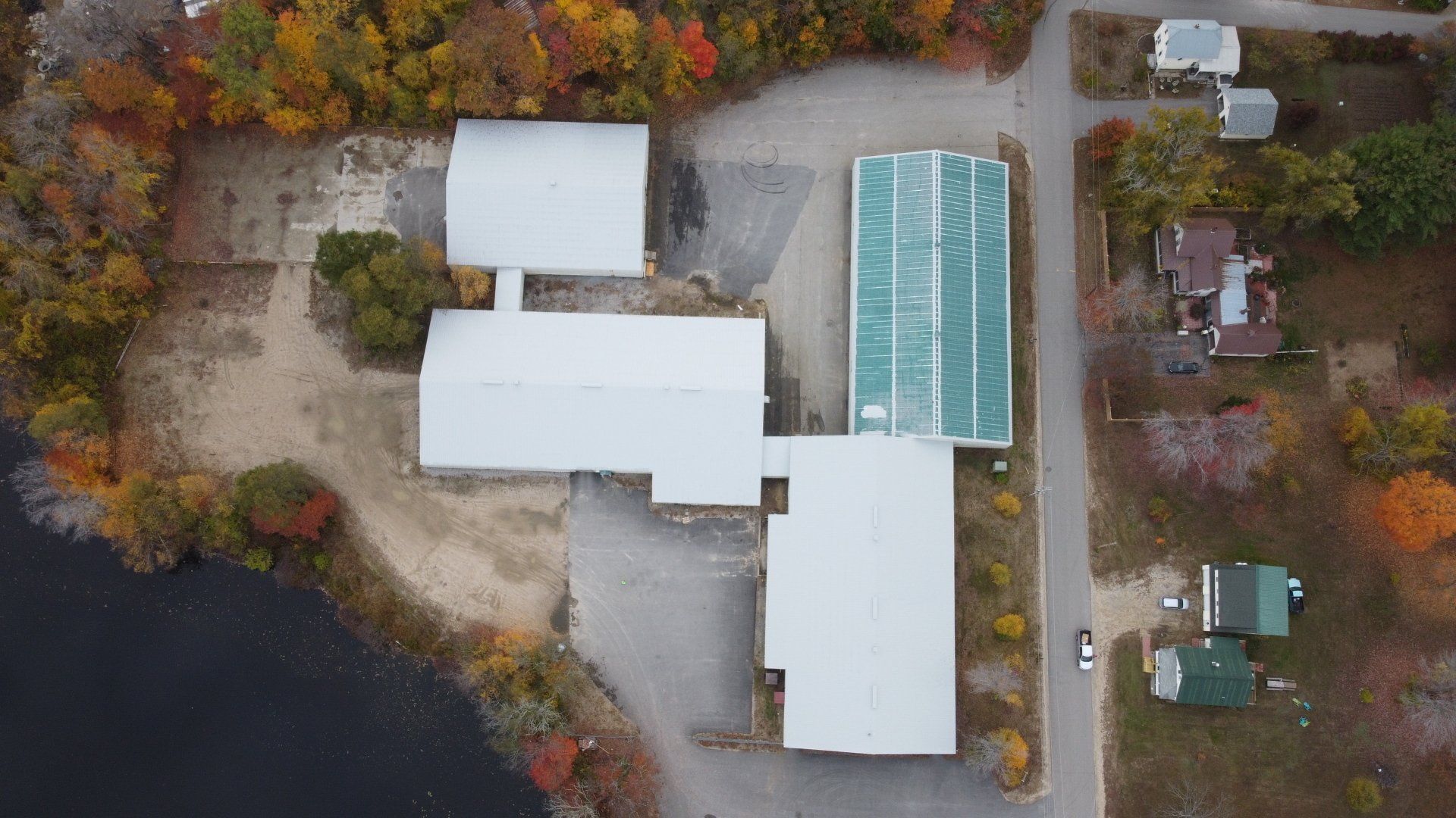 An aerial view of a large building surrounded by trees and a lake.