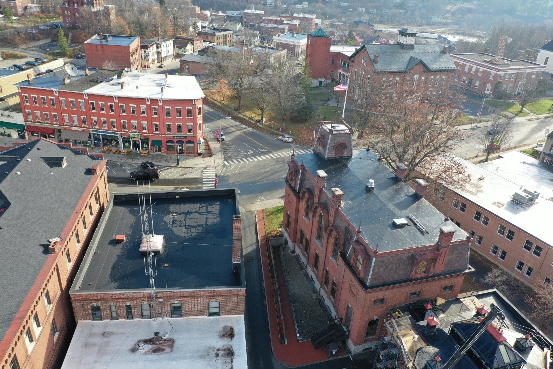 single-ply projects - Aerial view of a historic town with red brick buildings and bare trees.