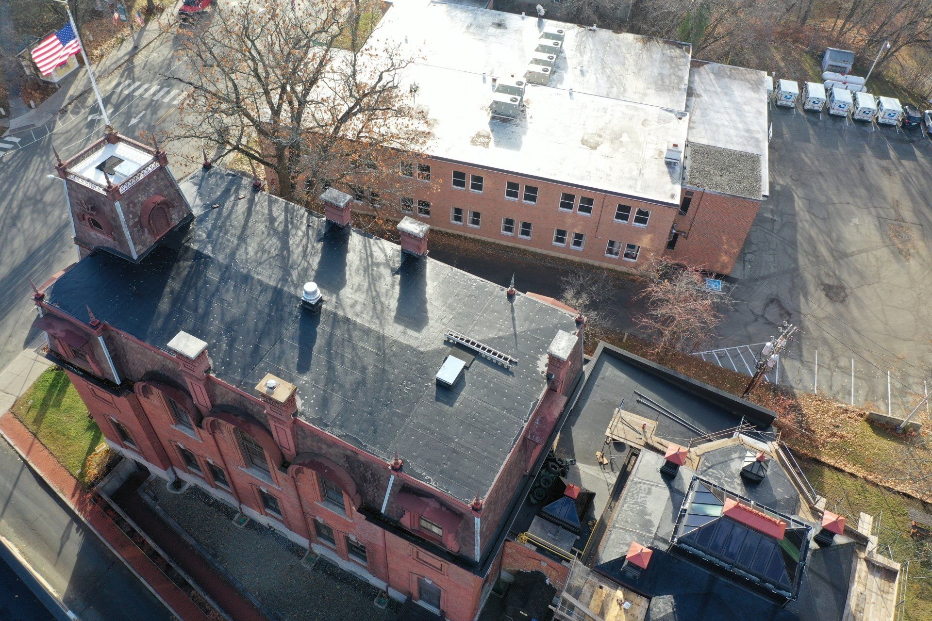 single-ply projects - Aerial view of a historic brick building with an adjacent parking lot.