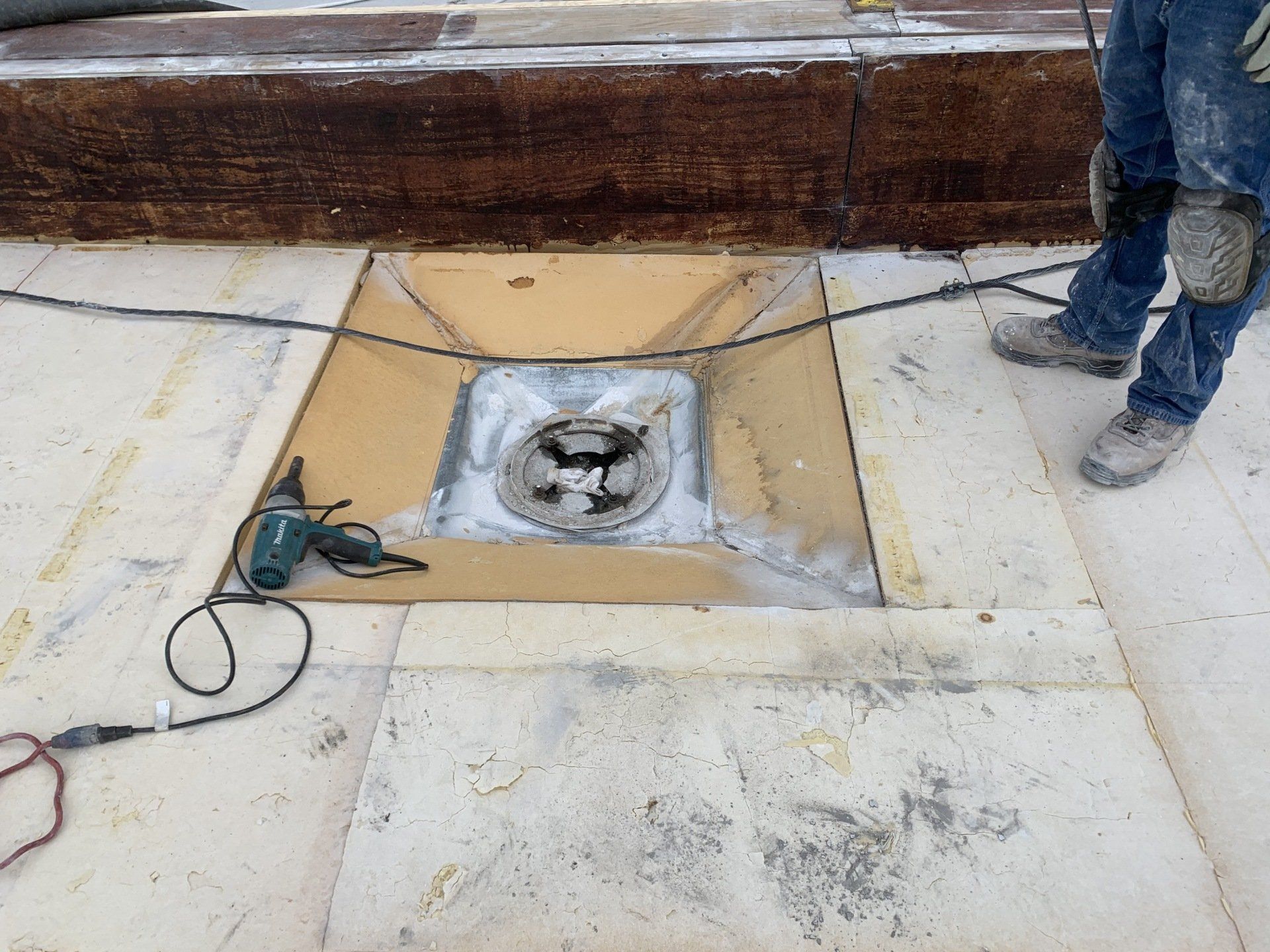 A man is working on a roof with a drill