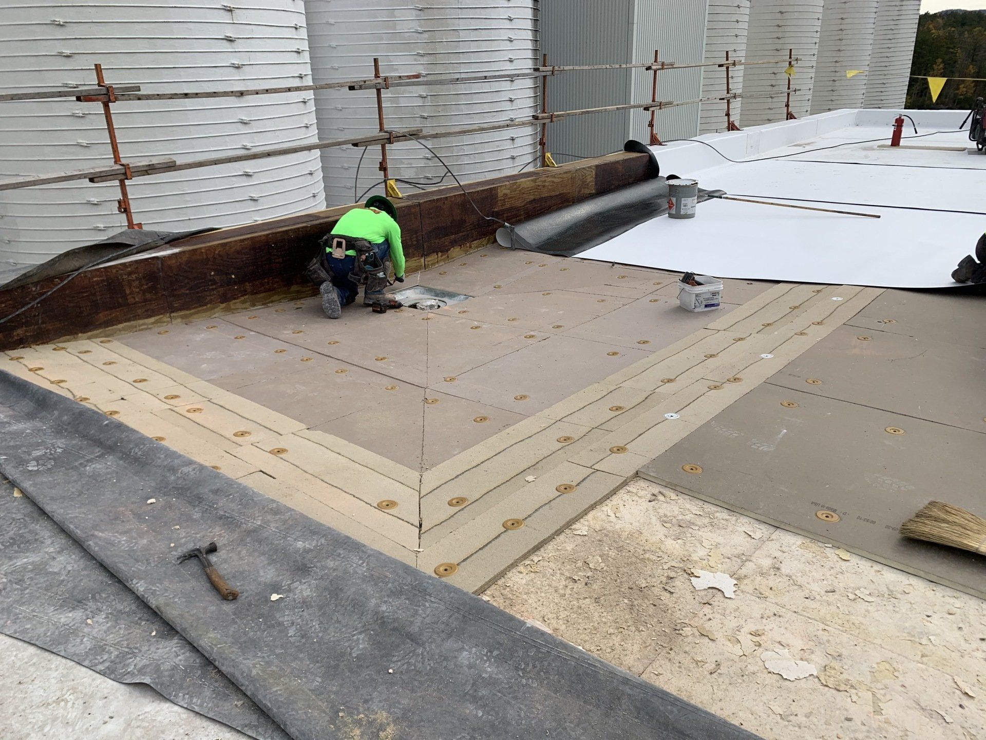 A man is working on a roof with a hammer.
