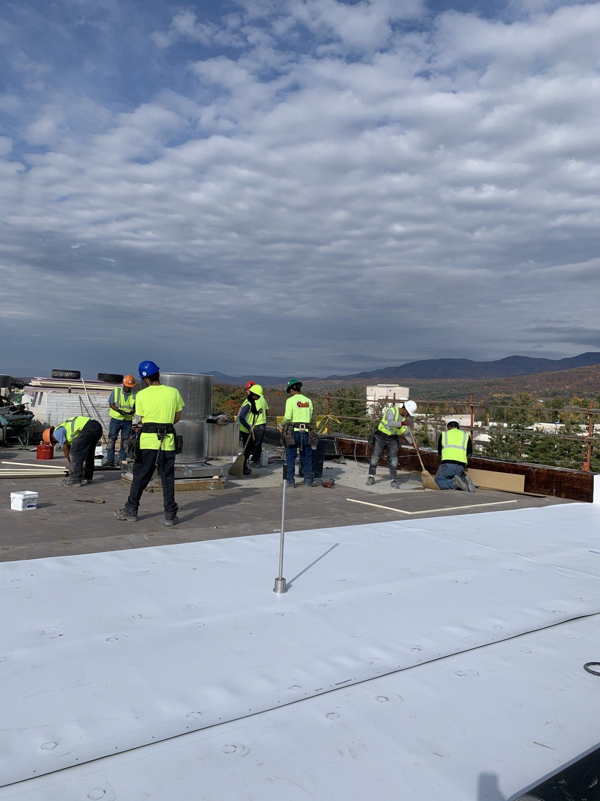 A group of construction workers are working on a roof