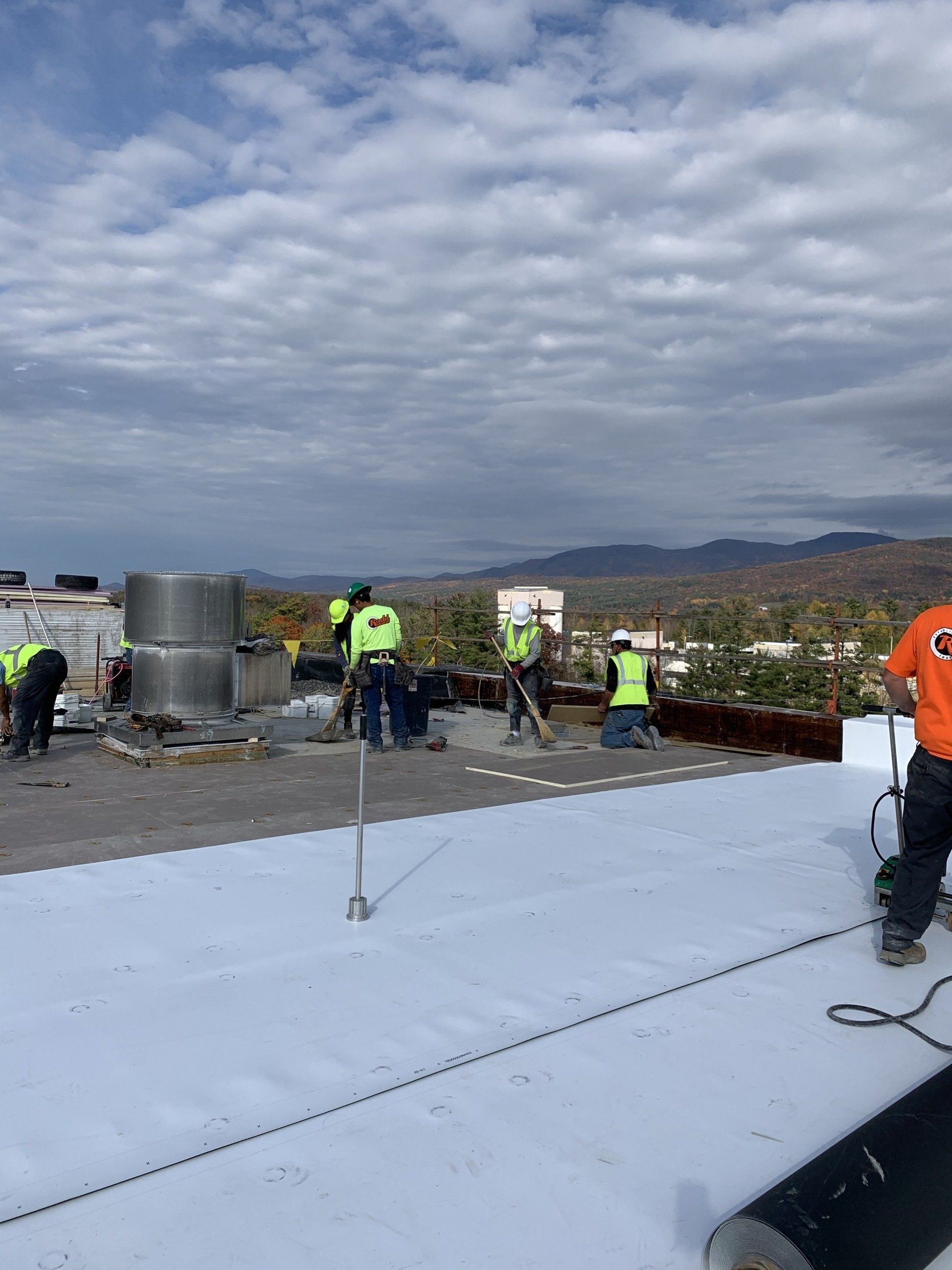 A group of people are working on a white roof.