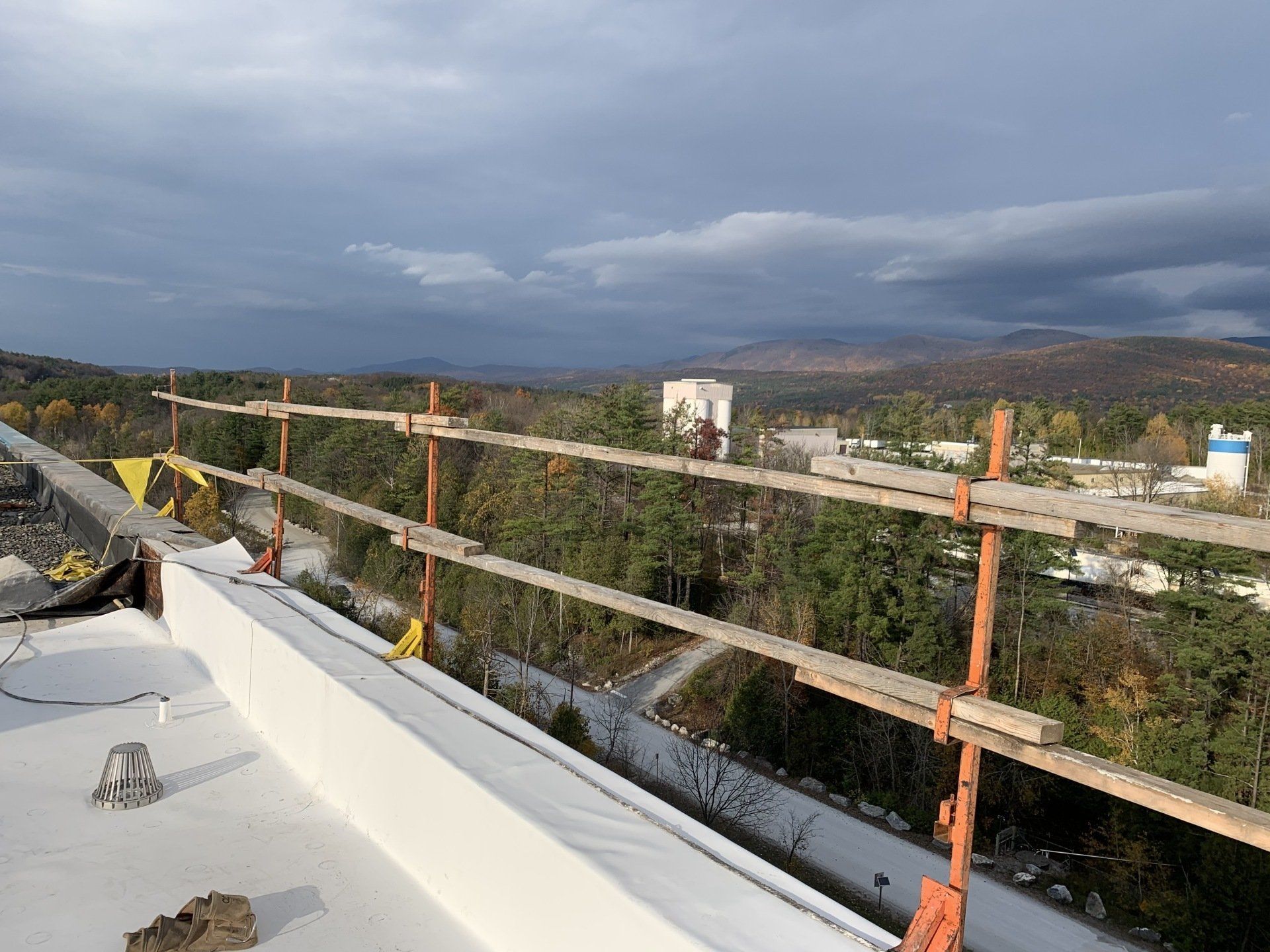 A roof with a fence on it and a view of a city.