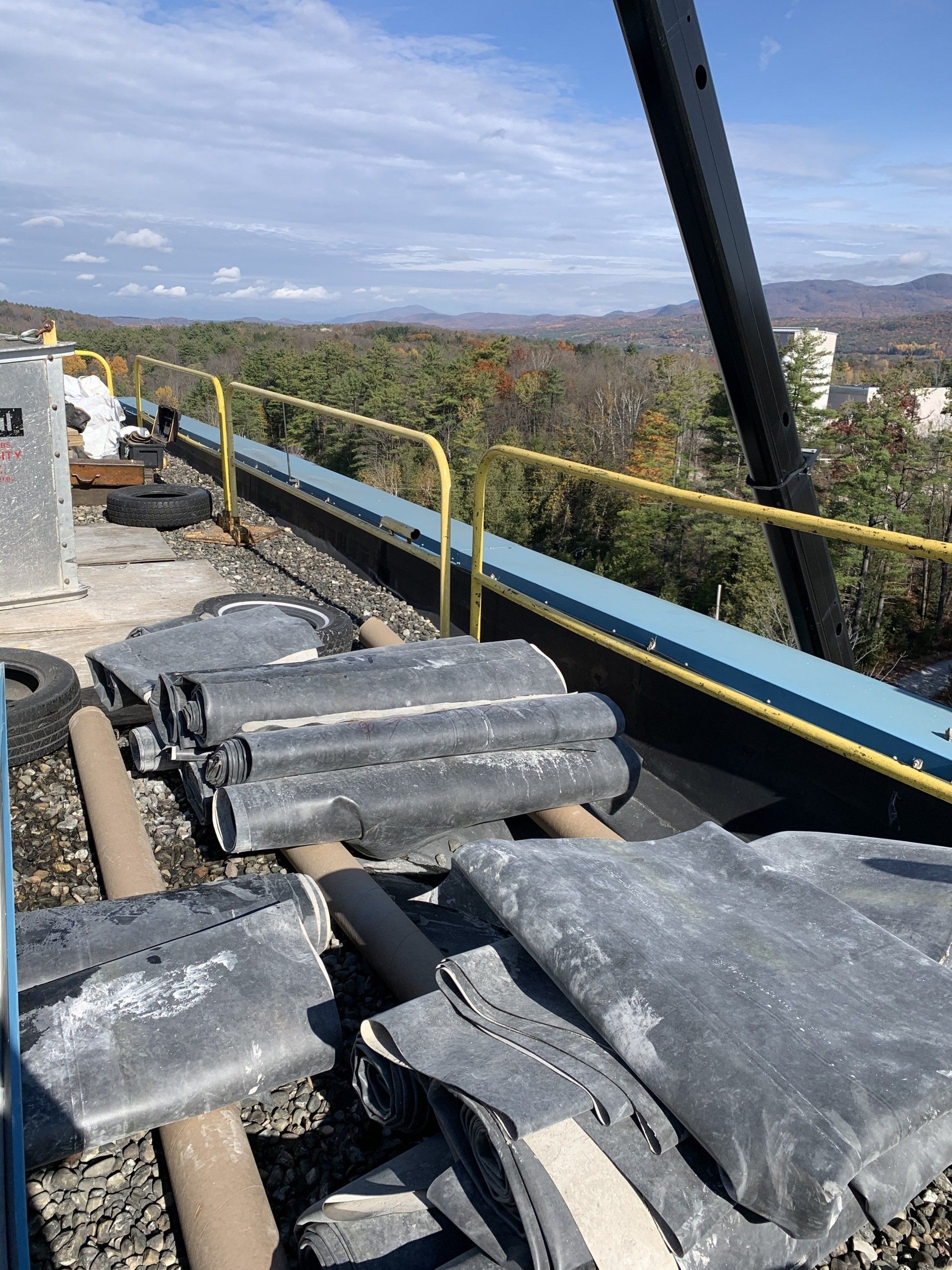 A bunch of blankets are sitting on top of a roof.