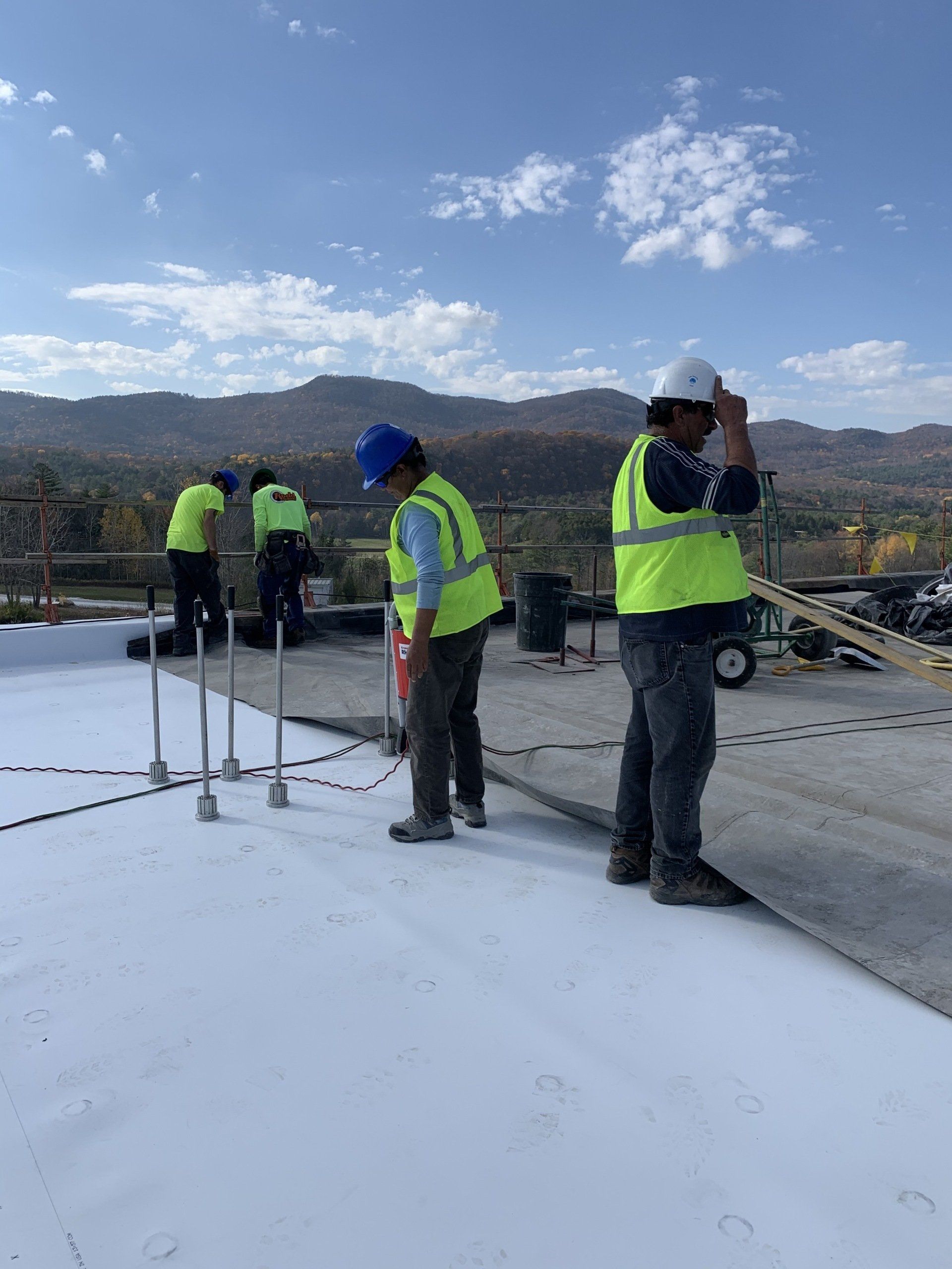 A group of construction workers are working on a roof.