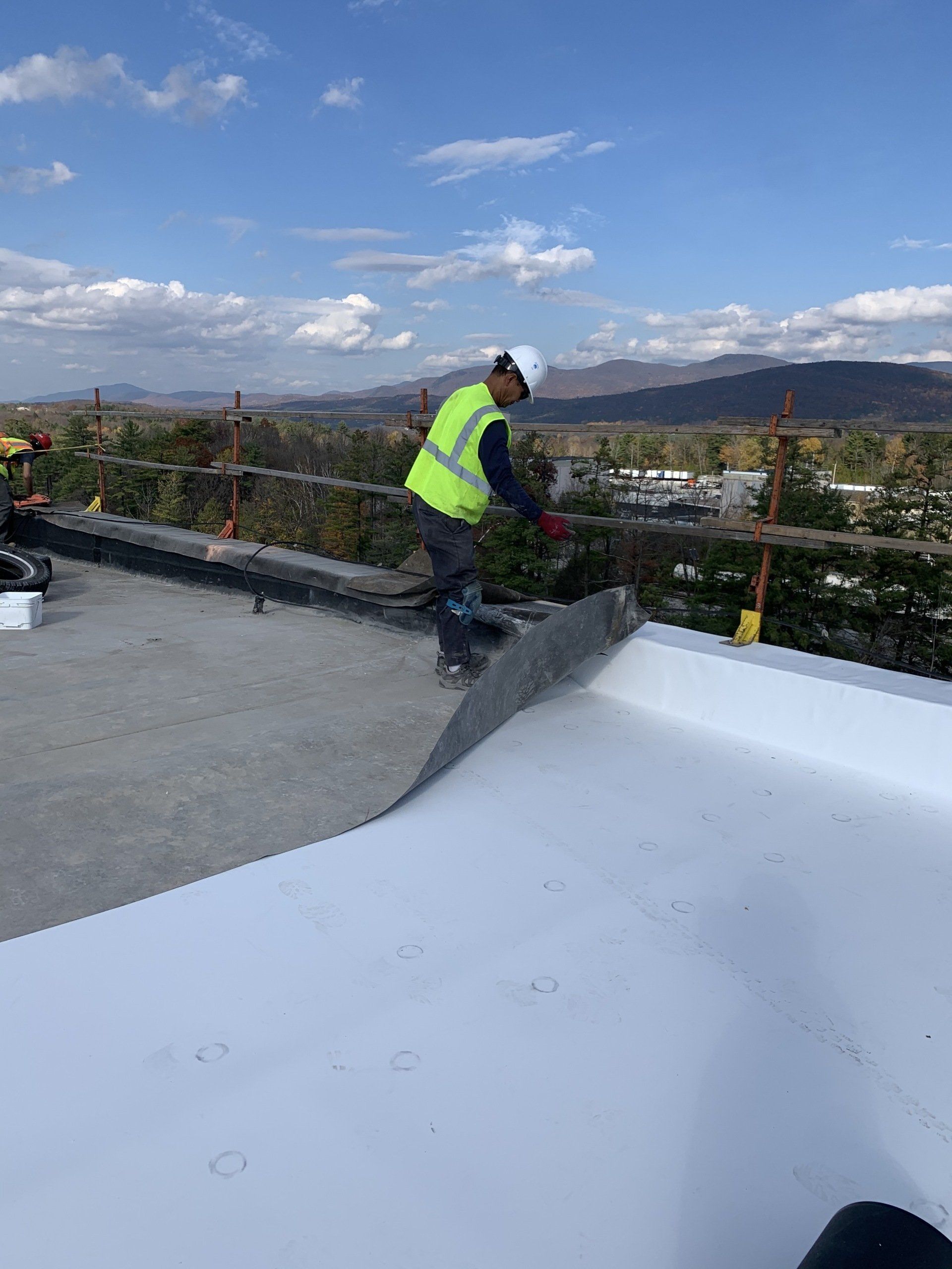 Rodd Roofing employee on a roof undergoing a single ply membrane installation in Vermont