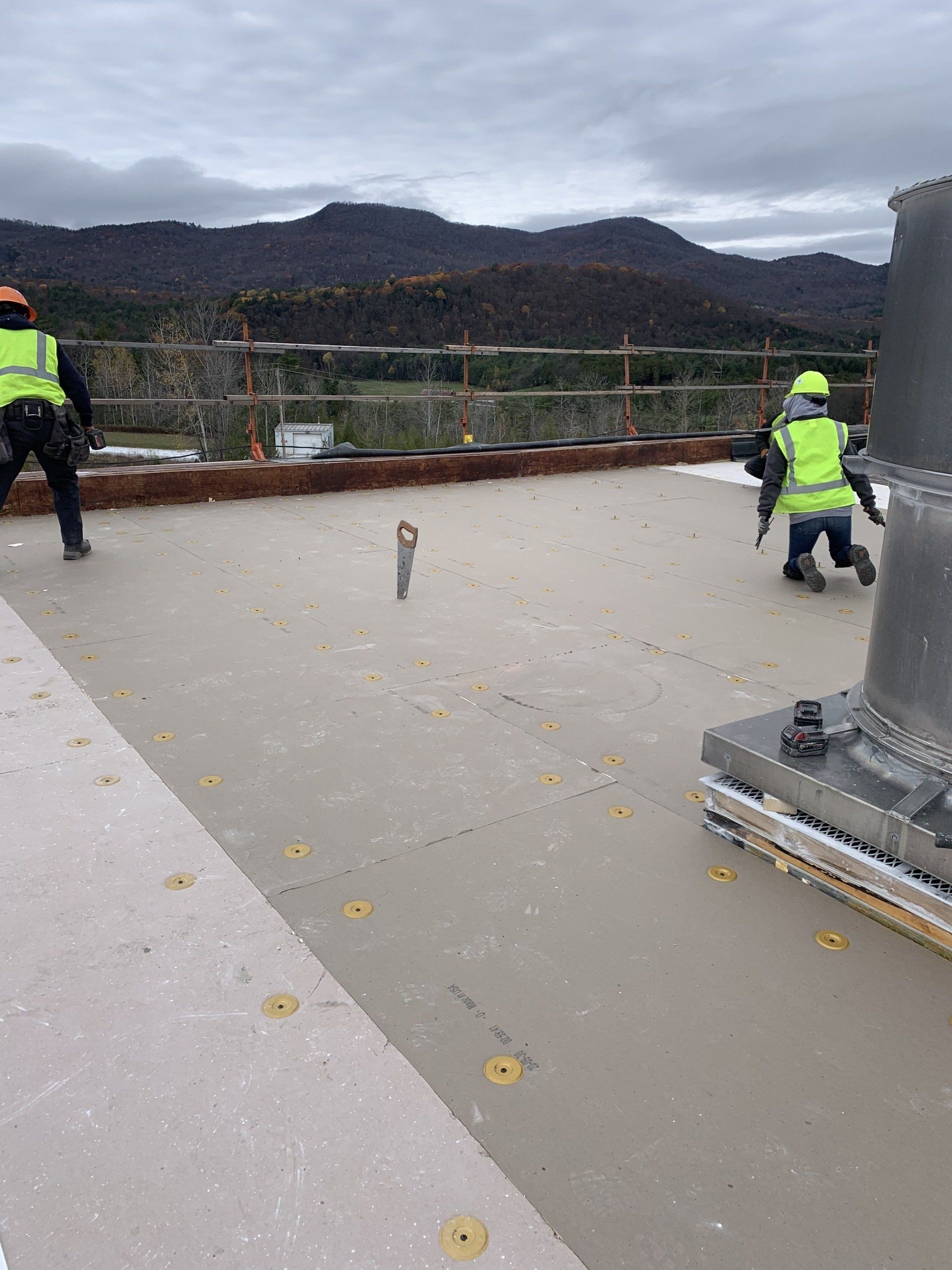 A group of construction workers are working on a roof.