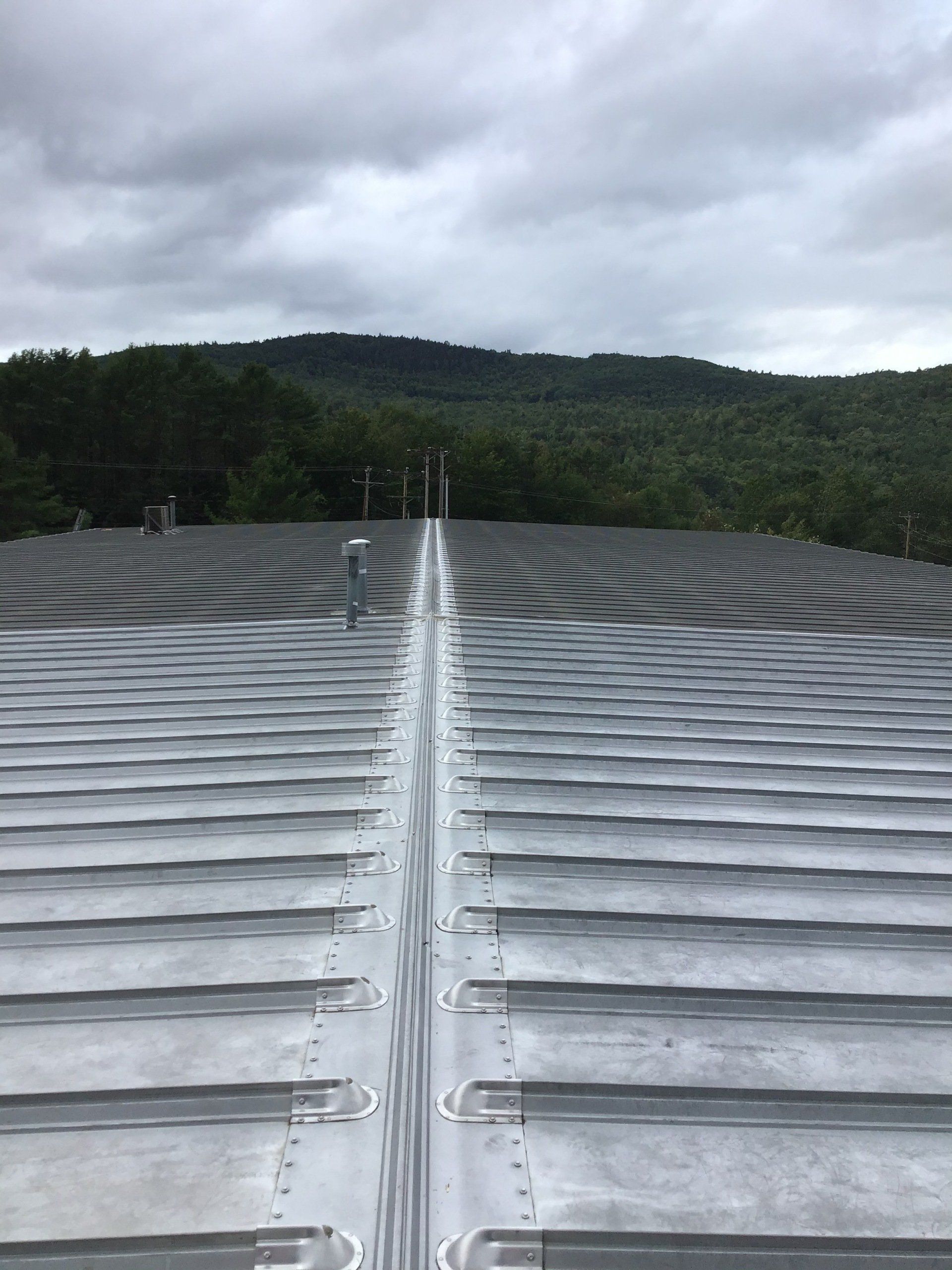 The roof of a building with a mountain in the background.