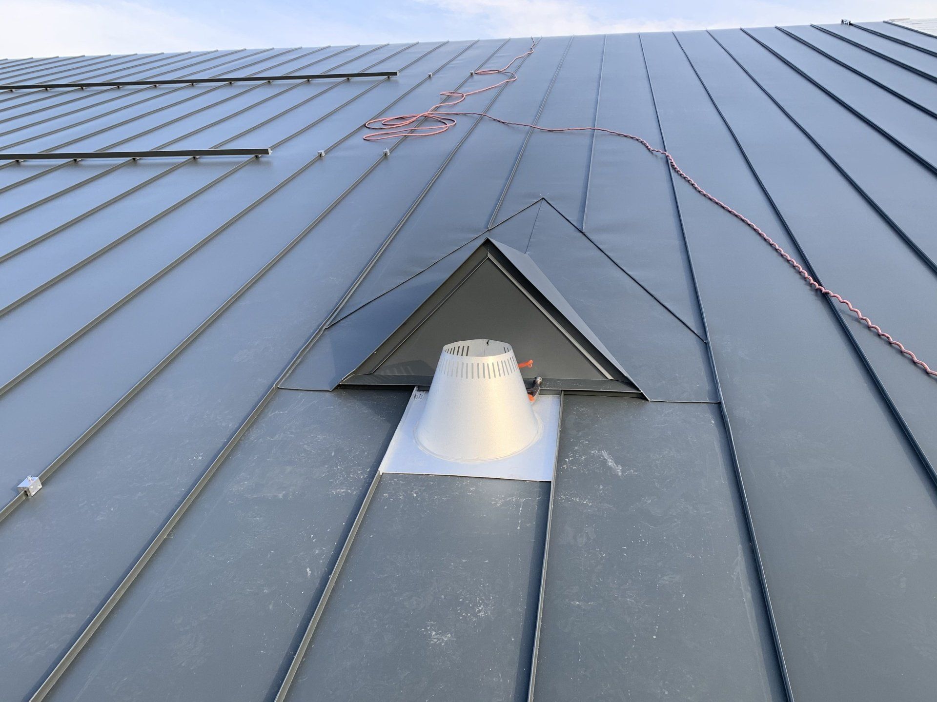 A gray roof with a white triangle on it