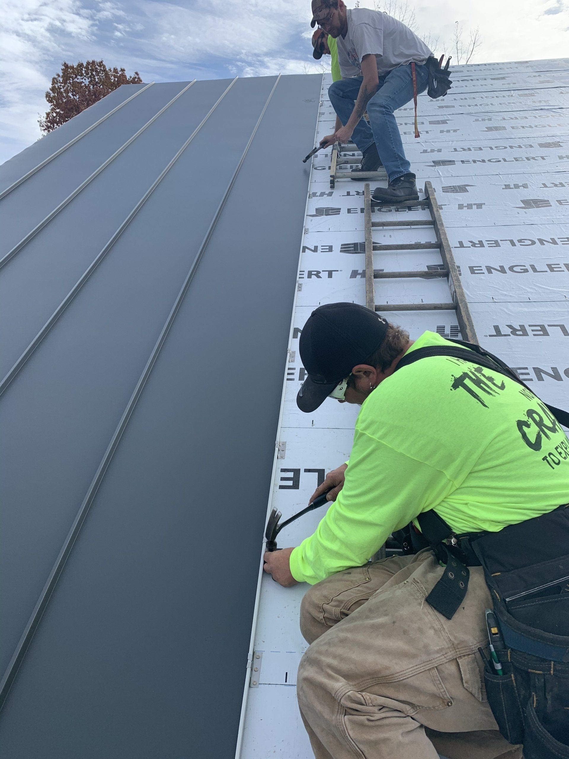 Two men are working on the roof of a building.
