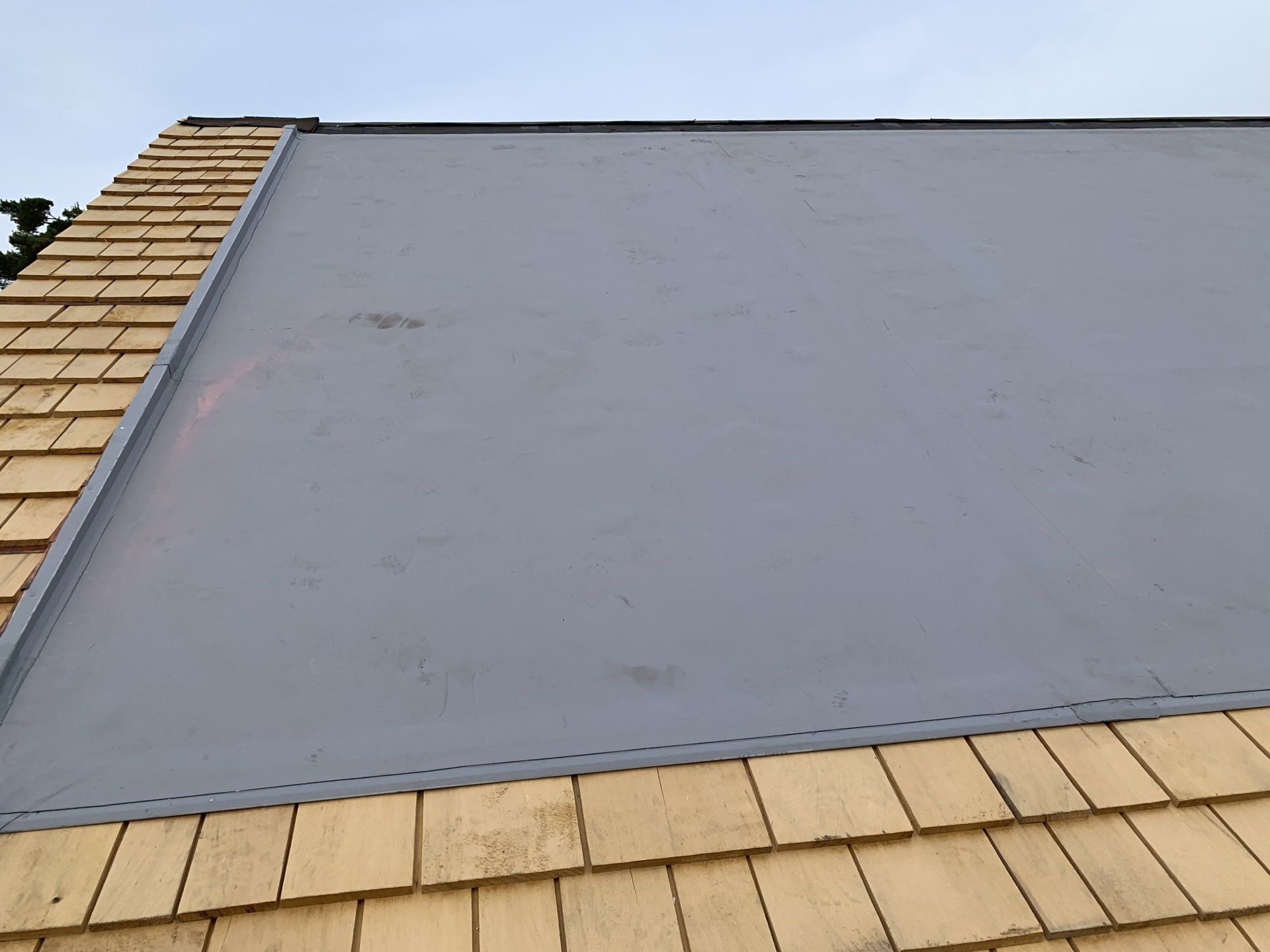 A roof with wooden shingles and a gray roof