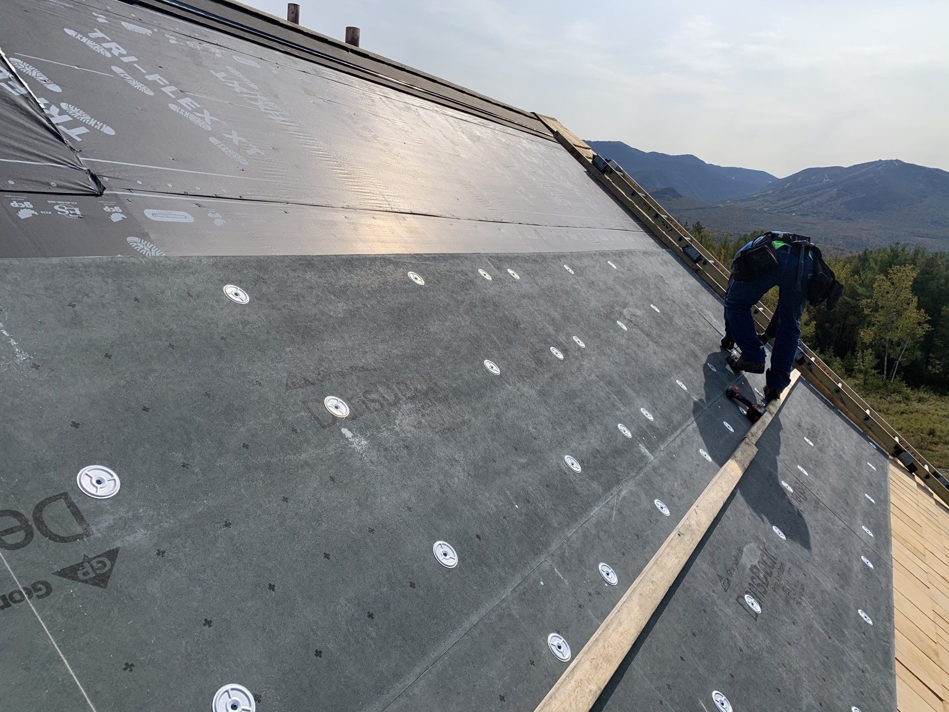A man is working on the roof of a building.