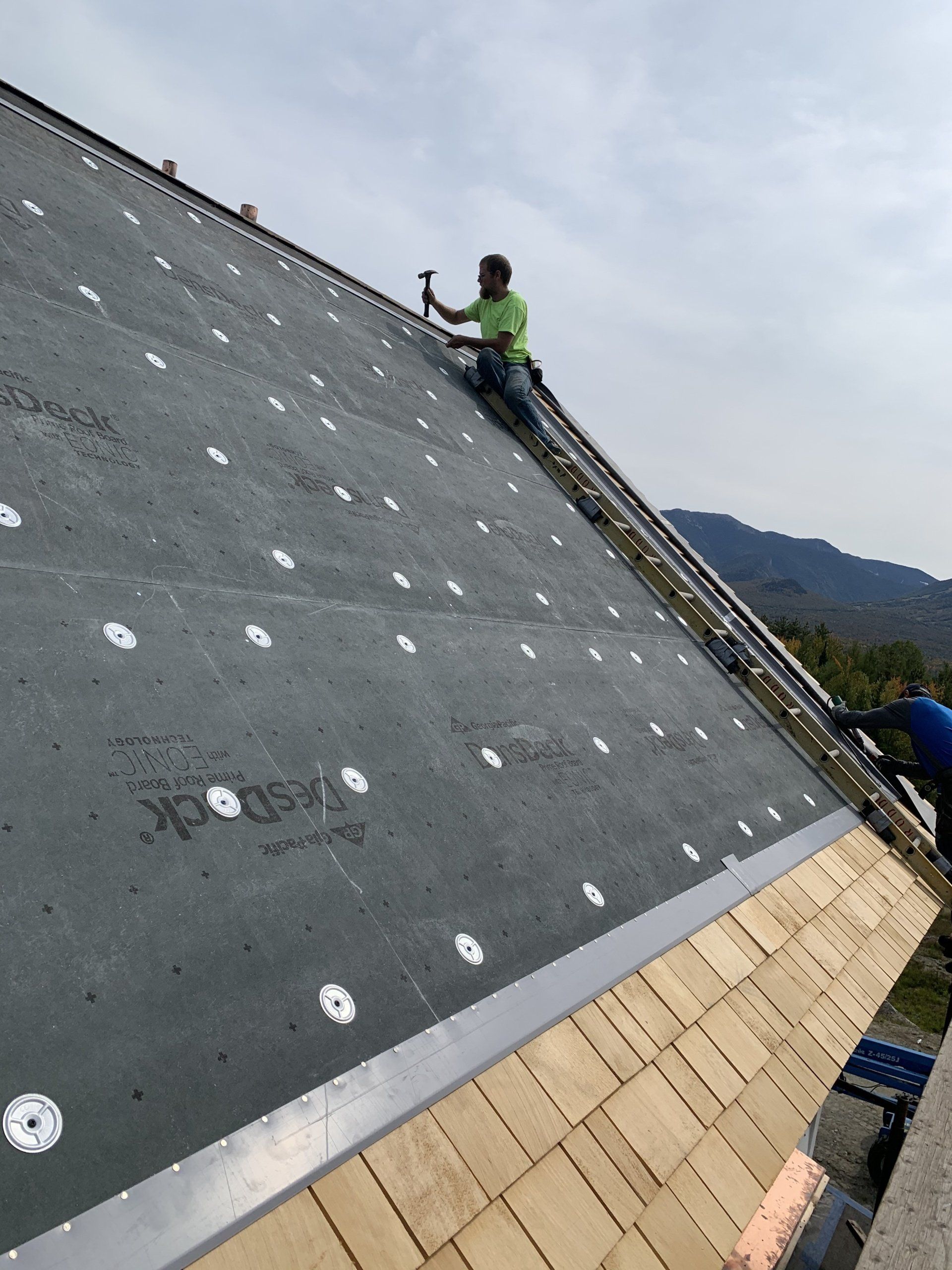 A man is working on the roof of a building
