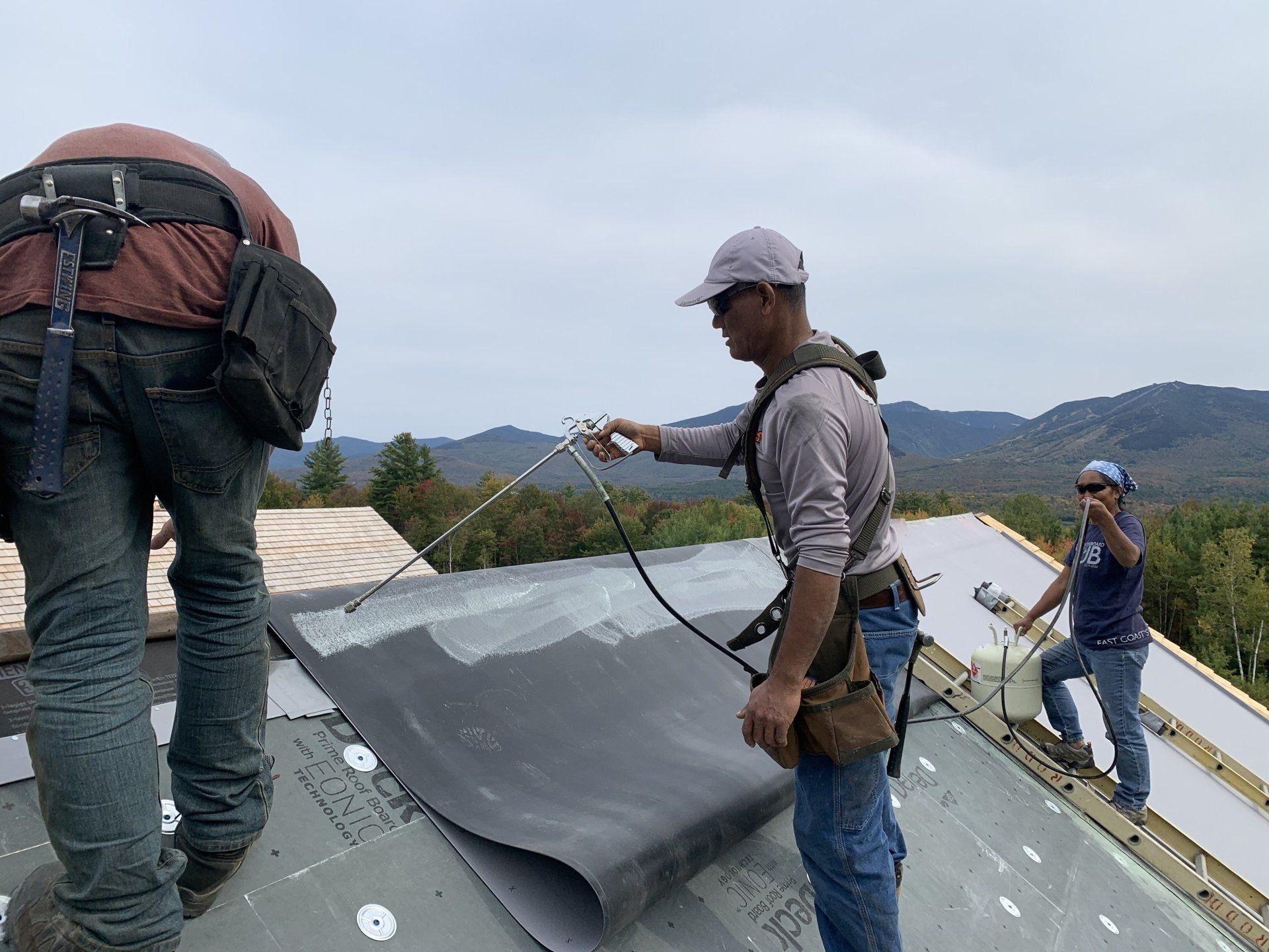 A group of men are working on a roof.