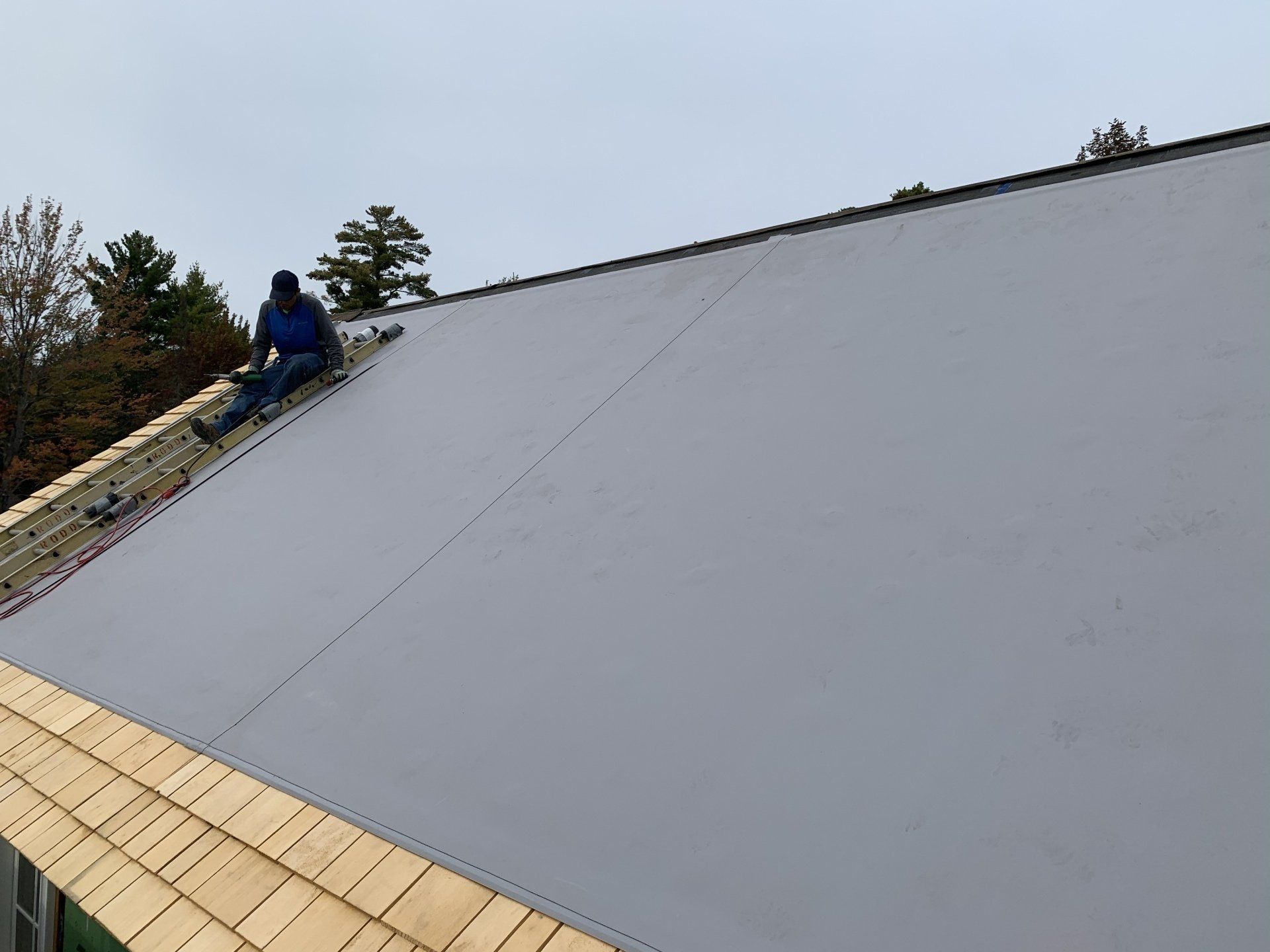 A man is sitting on the roof of a building.