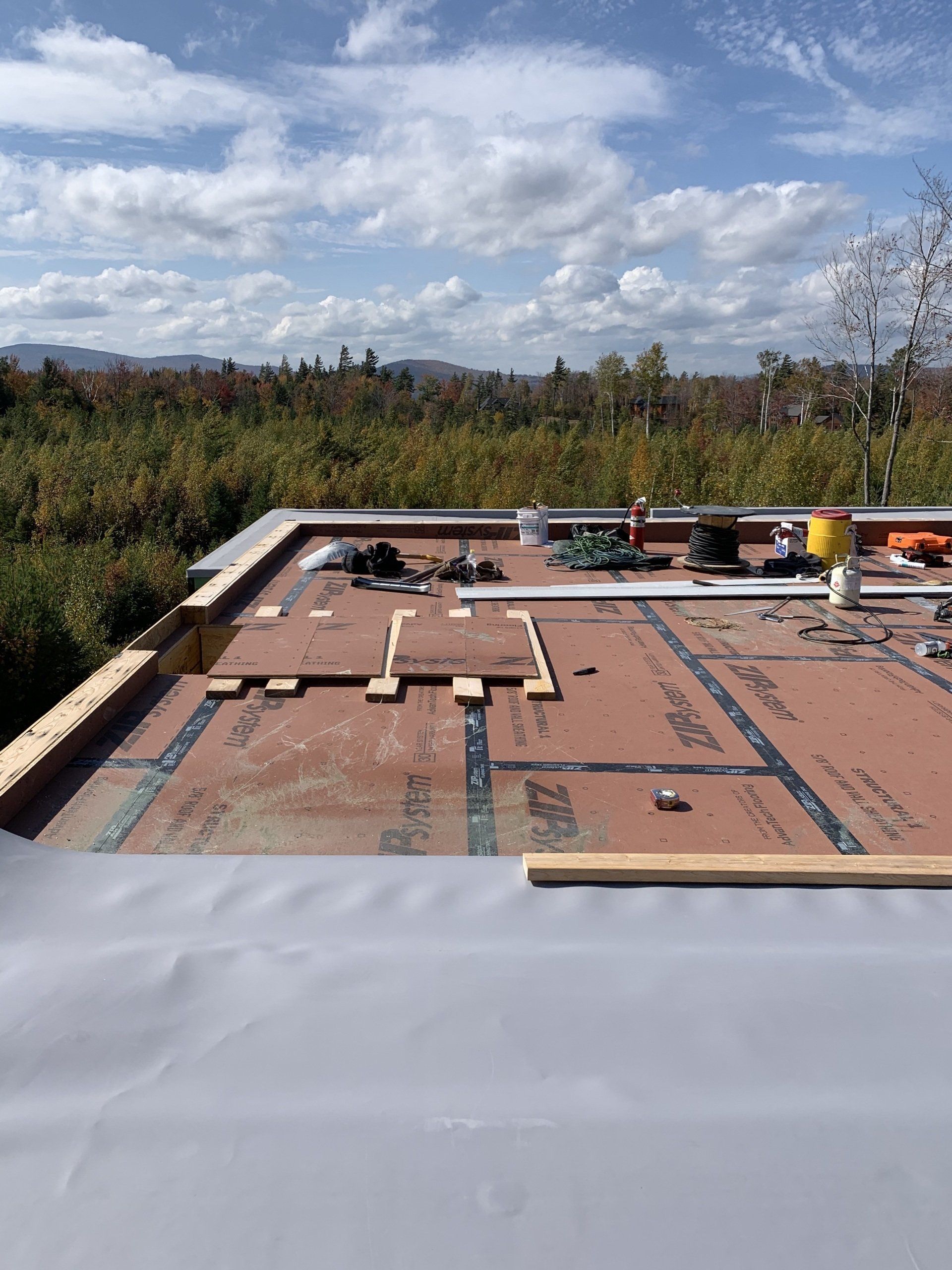 A commercial building with a newly installed TPO roofing system overlooking a Vermont landscape