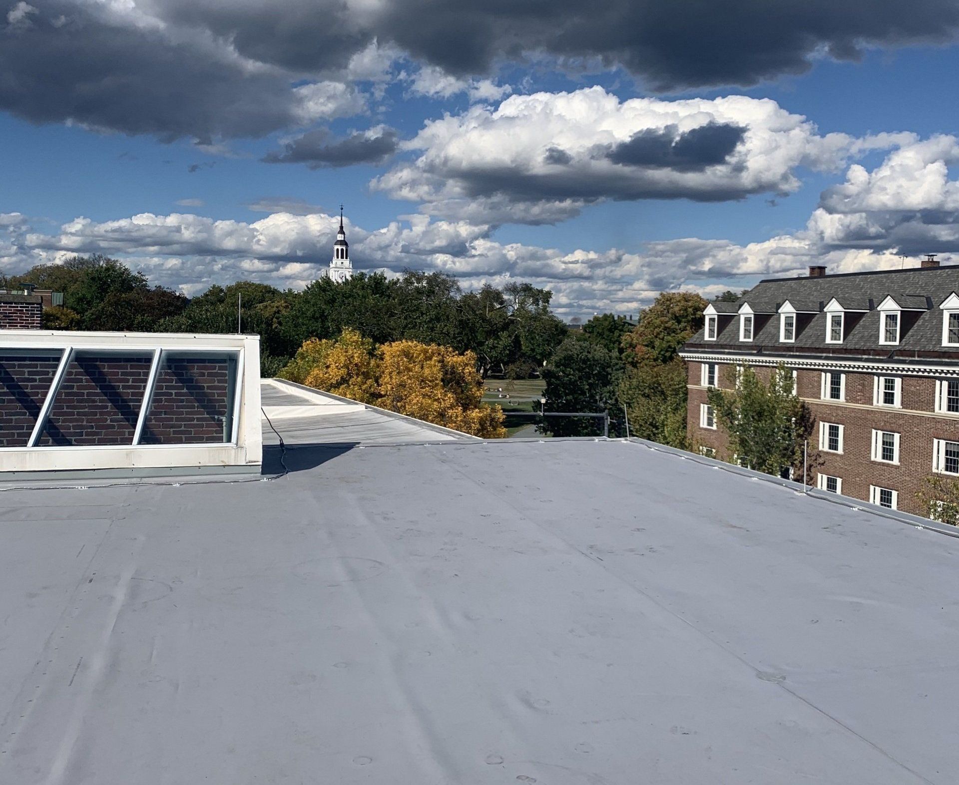 A commercial flat roof with skylights overlooking a Vermont town