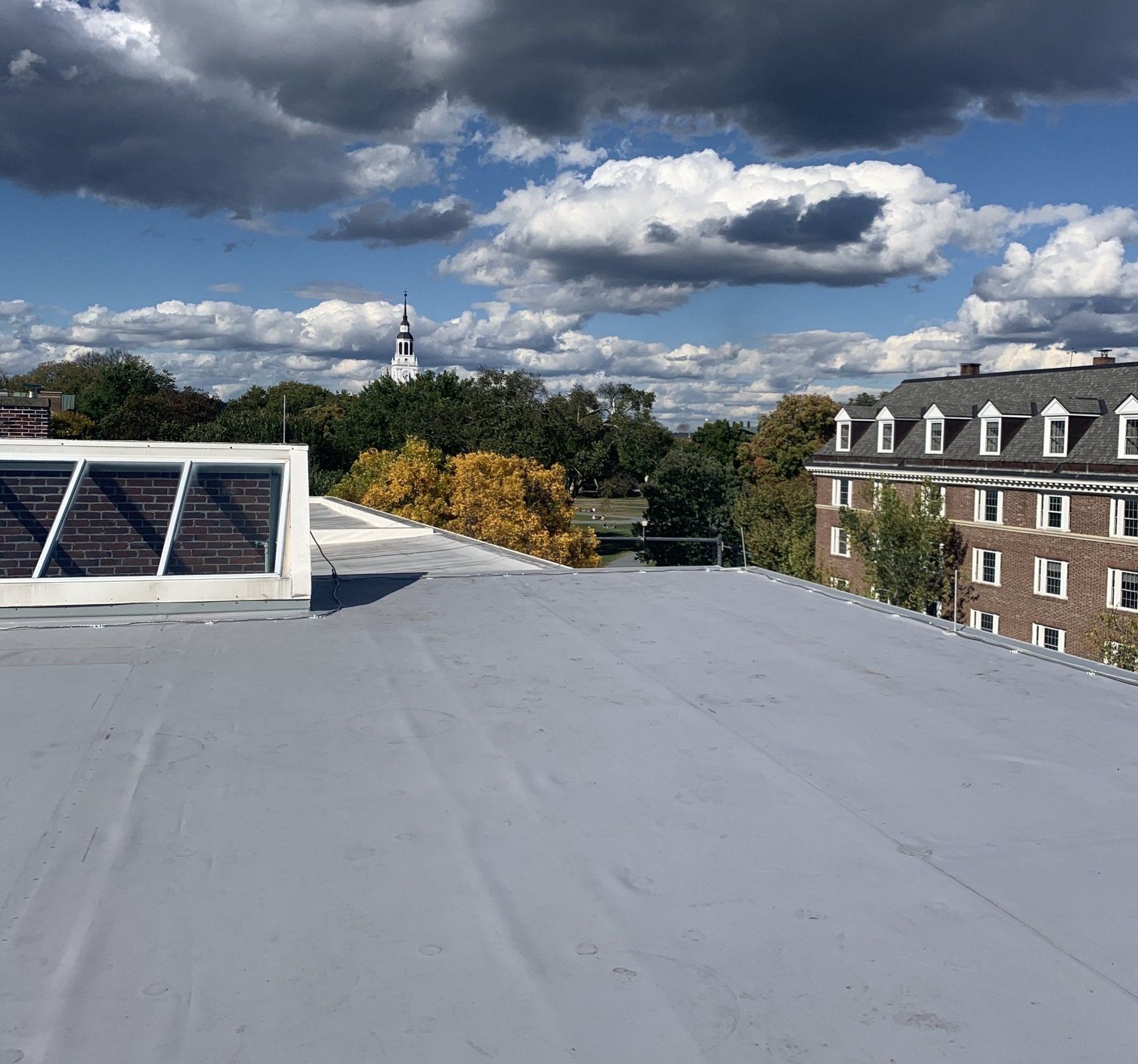 Flat commercial roof with shingles and skylights