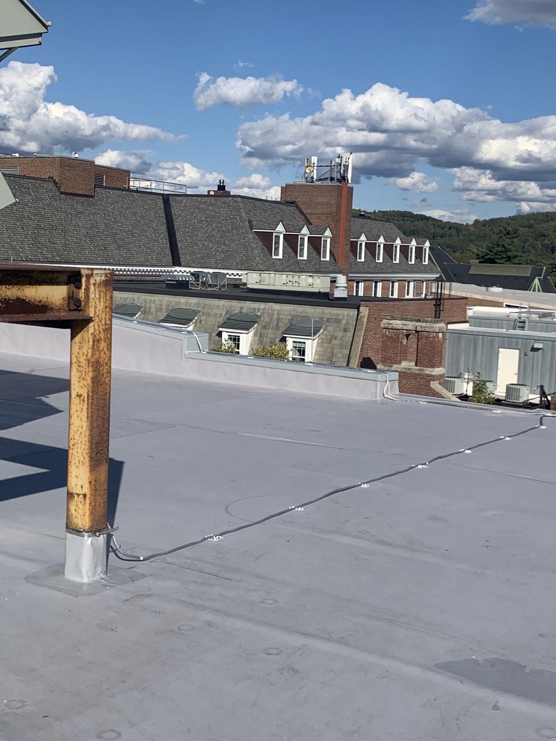 The roof of a building with a wooden post on it