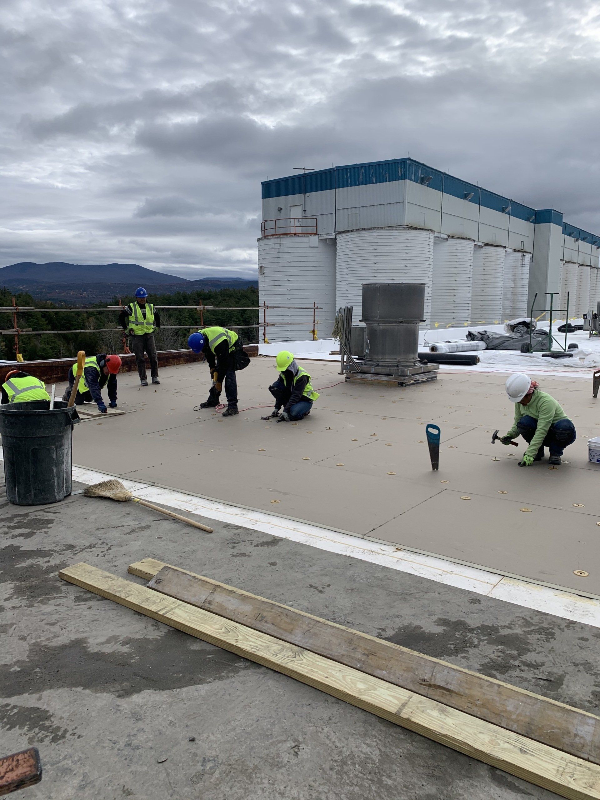 A group of construction workers are working on the roof of a building.