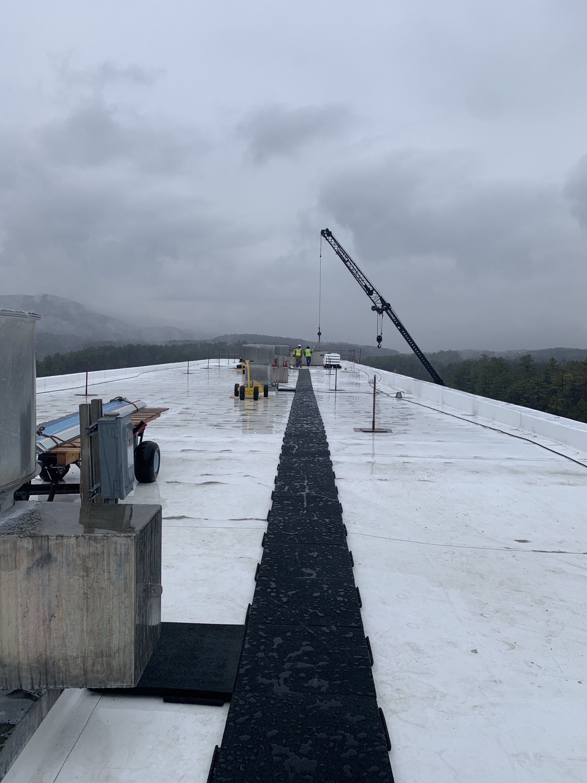 A white roof with a black path leading to it on a cloudy day.