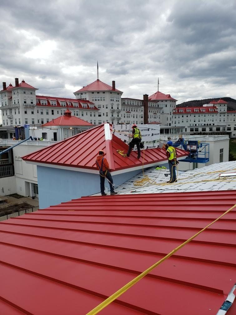 A group of men are working on the roof of a building.