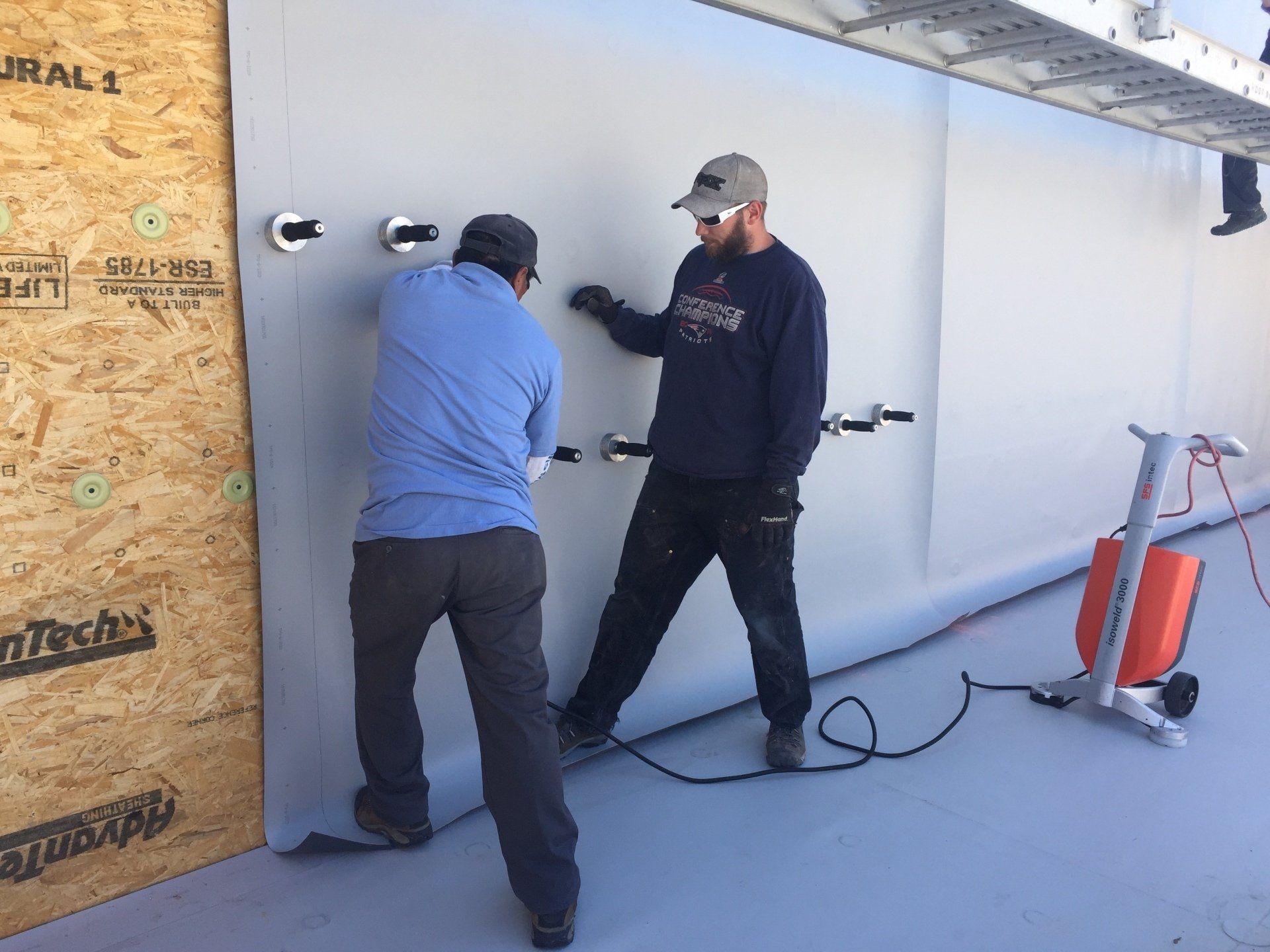 Two men are working on a wall that says ral 1 on it